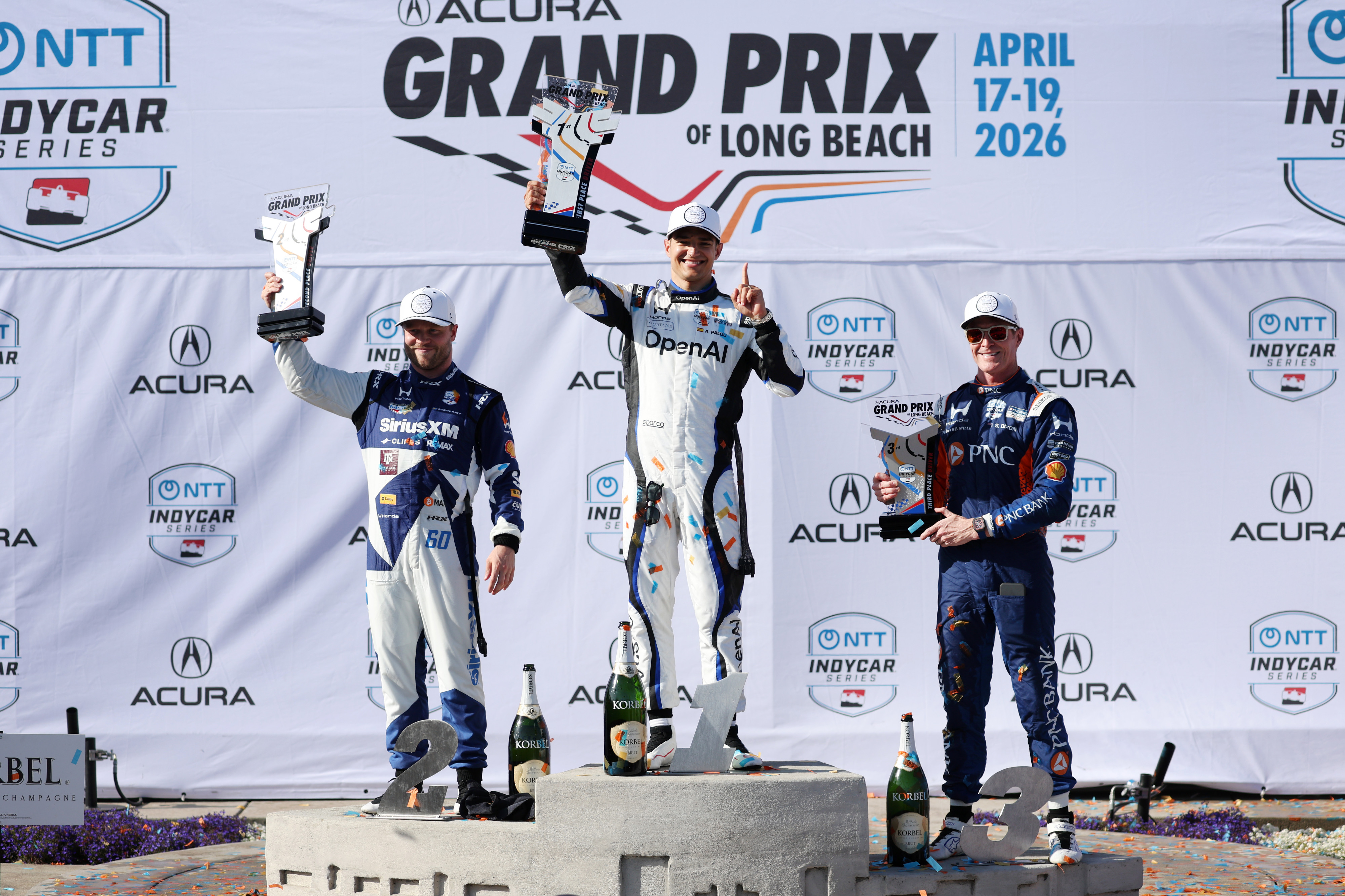 Winning Indycar driver Alex Plaou, center, celebrates alongside second place...