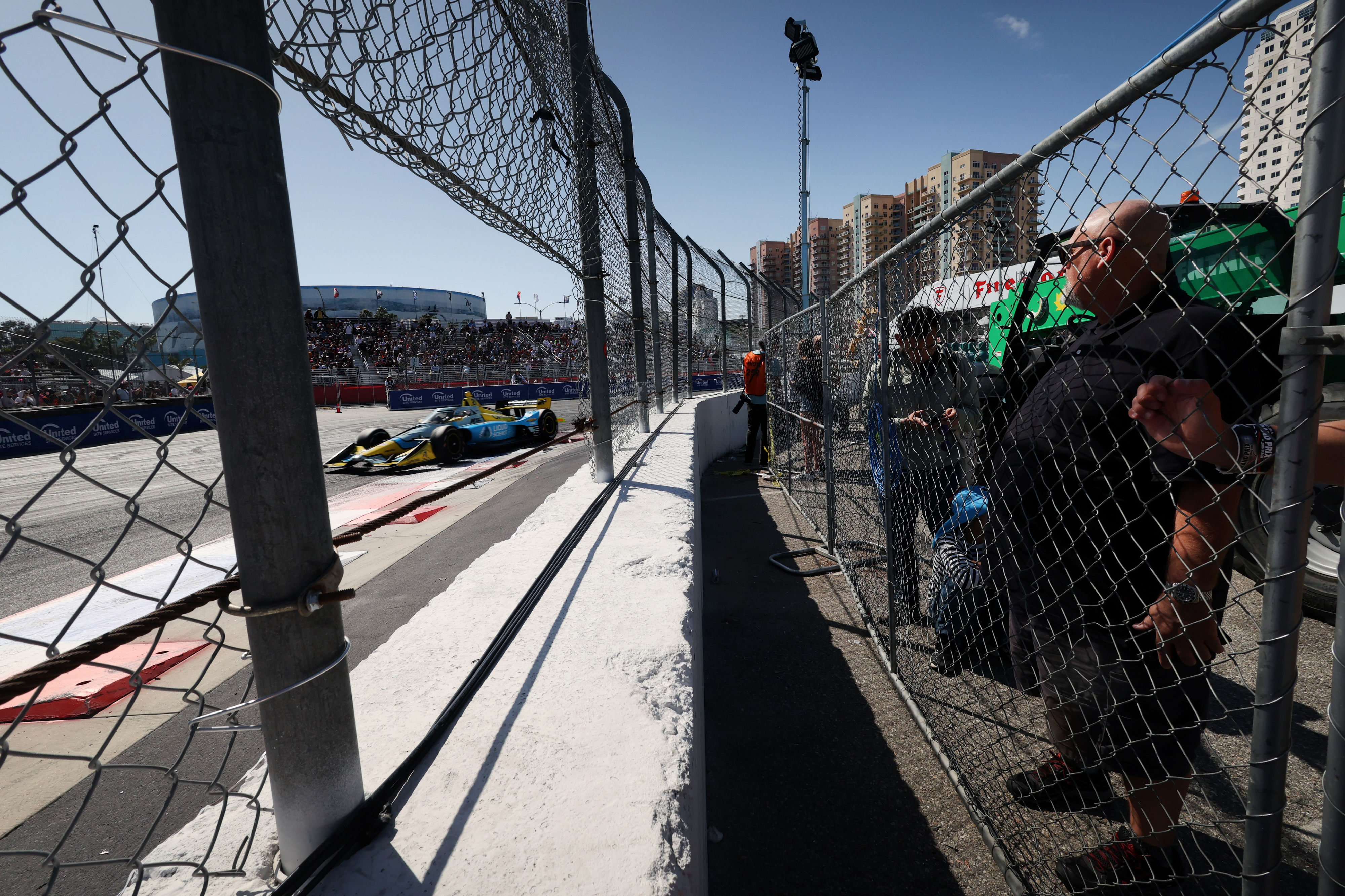 Fans watch as Indycar driver Christian Rasmussen races around turn...