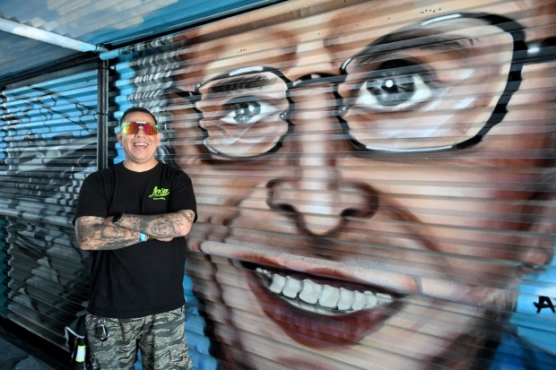 Artist, Jose "Dooms" Pedroza, on Tuesday, April 7, 2026, stands next to his mural honoring Grand Prix Association of Long Beach President & CEO Jim Michaelian, who died on Saturday, March 21, 2026. The Acura Grand Prix of Long Beach partnered with Long Beach-based nonprofit Creative Class Collective to commission a series of special murals on three of the event's pedestrian bridges. (Photo by Dean Musgrove, Los Angeles Daily News/SCNG)
