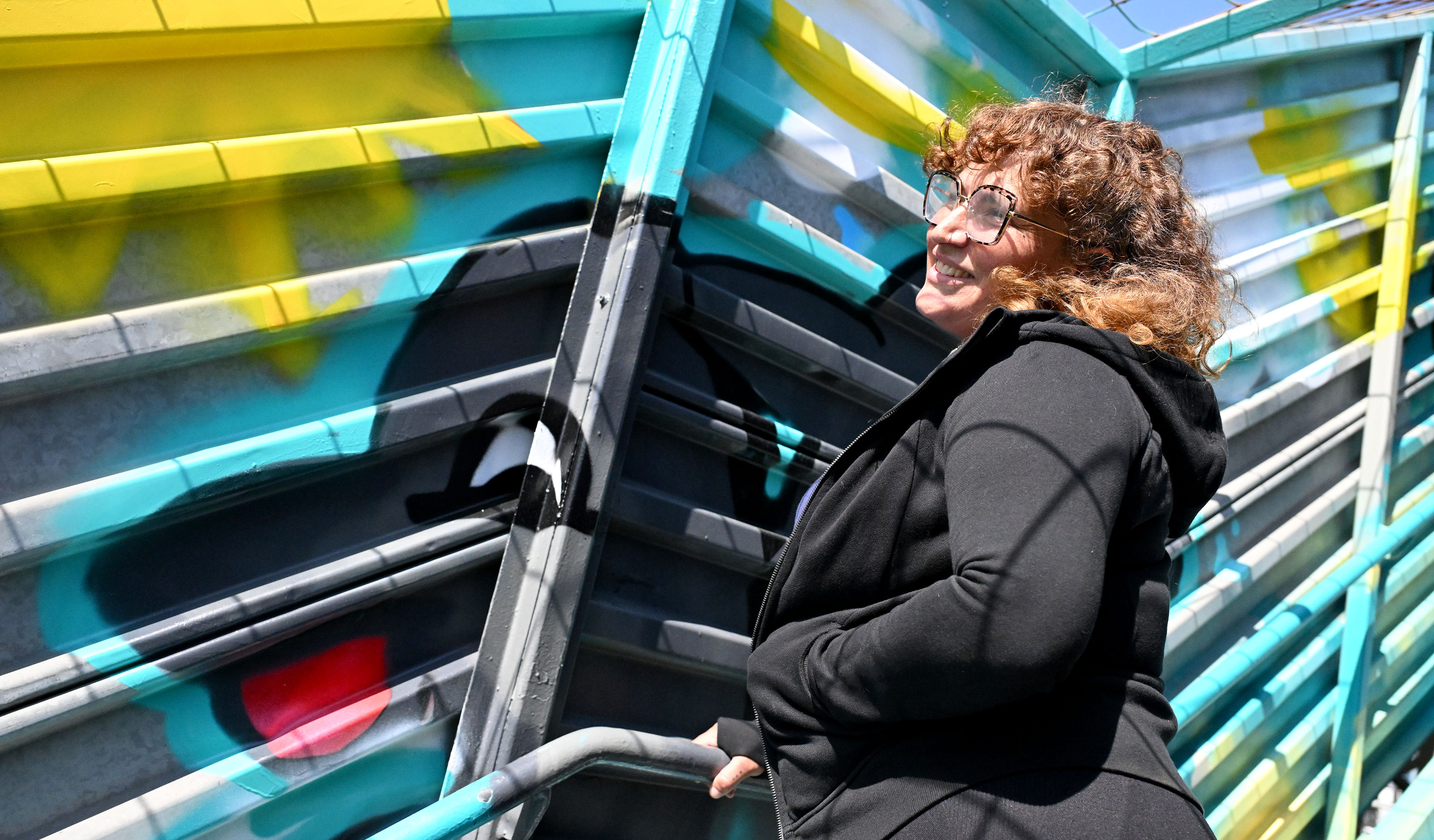 Artist, Jamiene âDLUXâ Andreozzi stands next to her mural of...