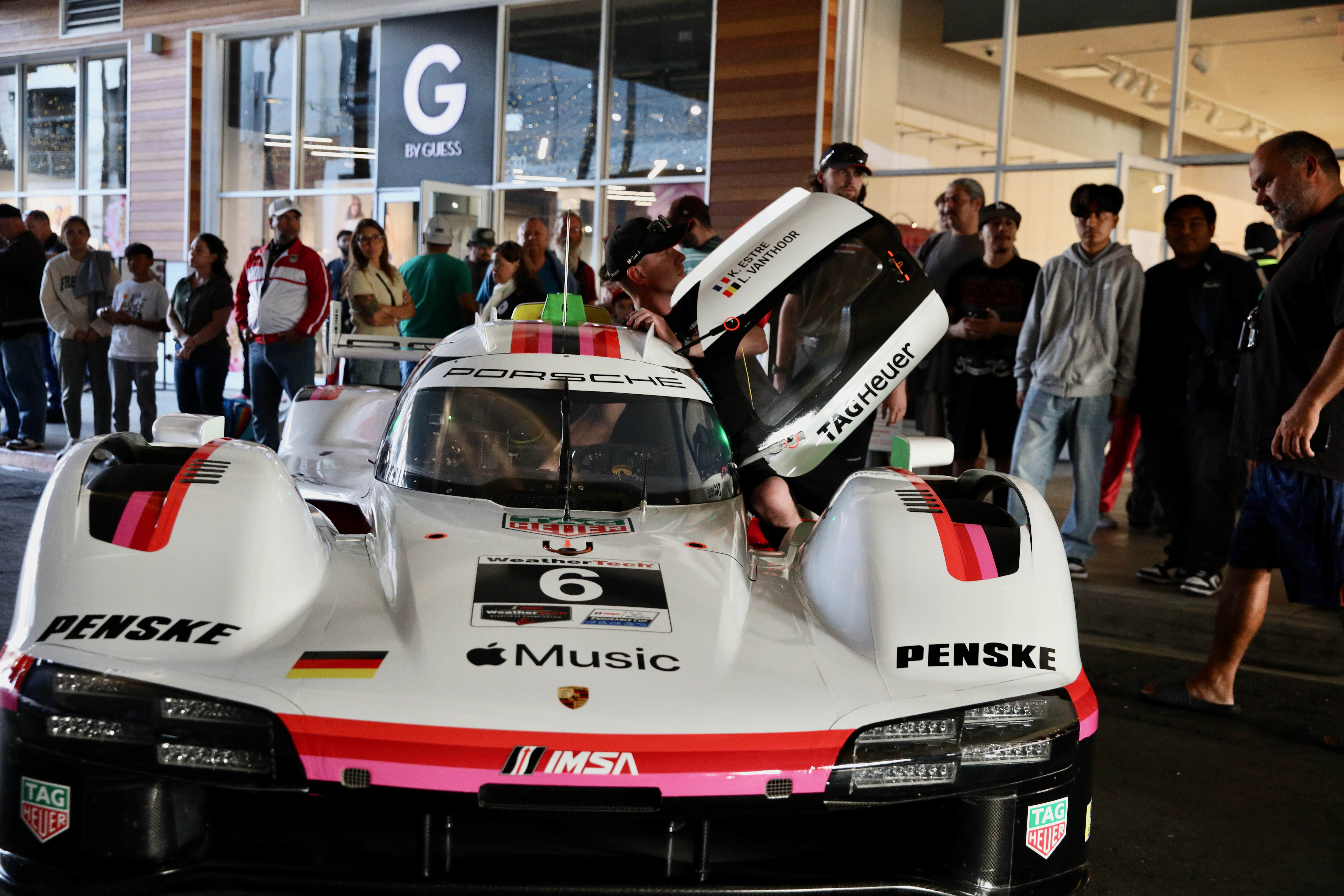 Attendees check out the various racing series cars and meet...