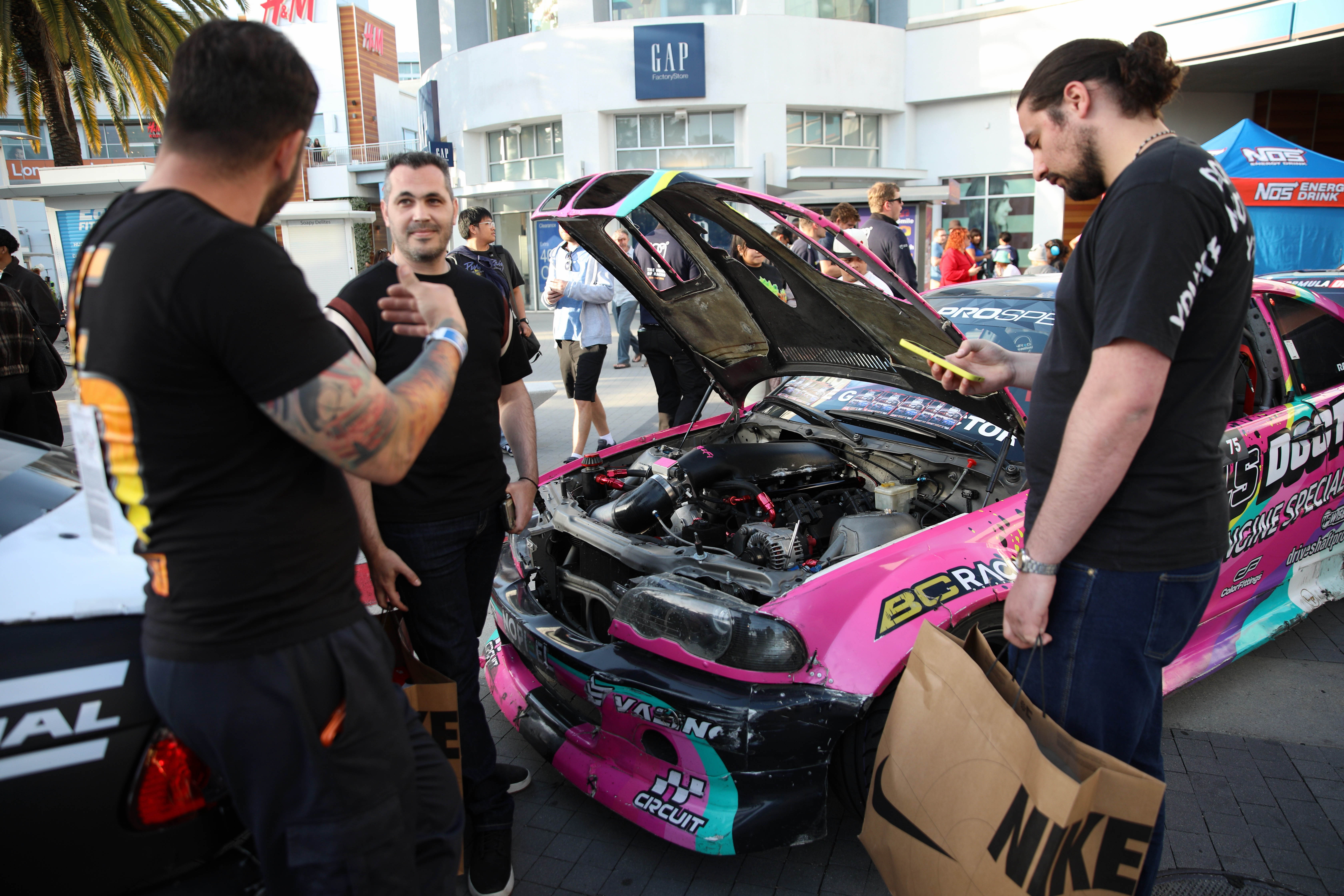 Attendees check out the various racing series cars and meet...