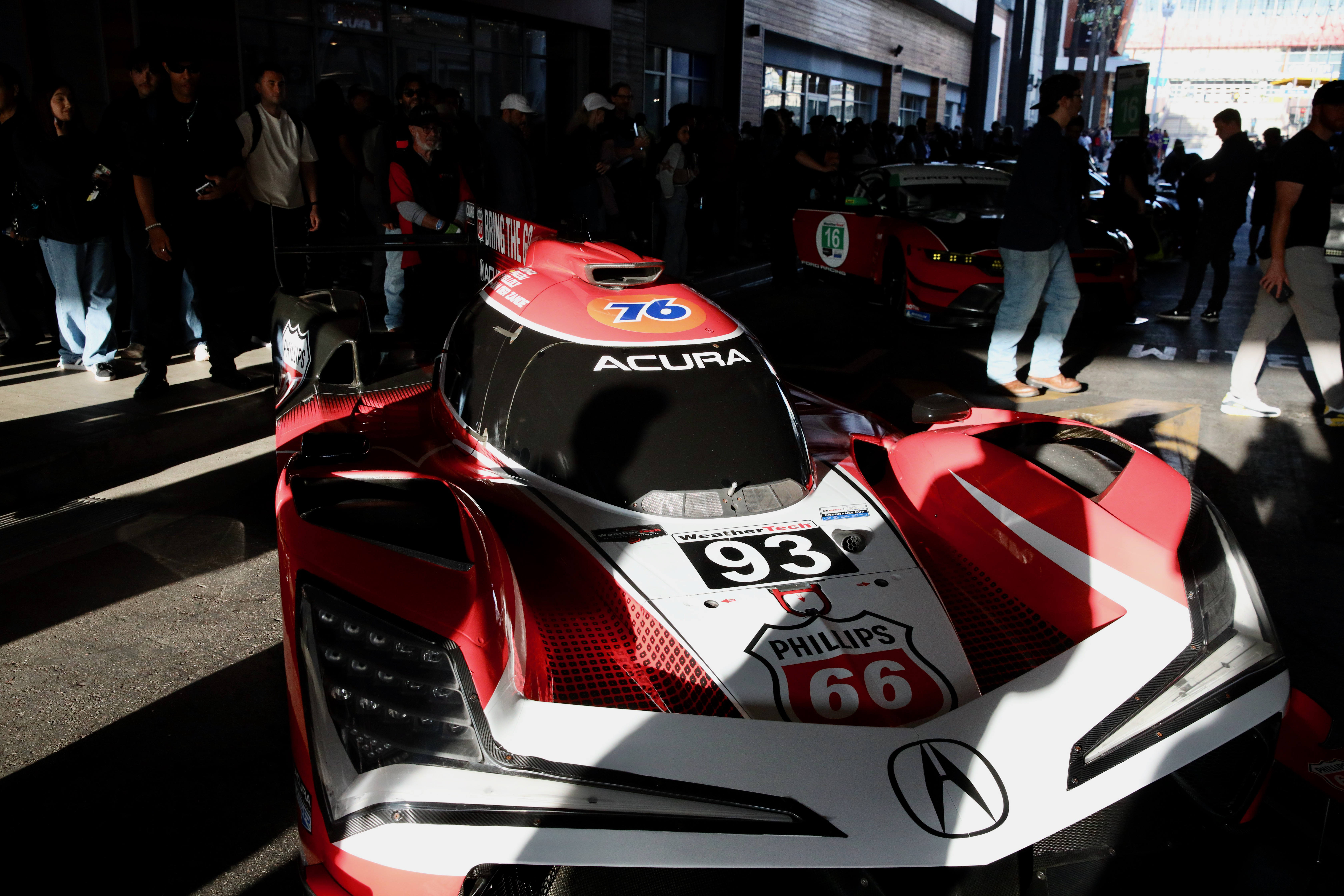 Spectators gather to see cars up close and to meet...