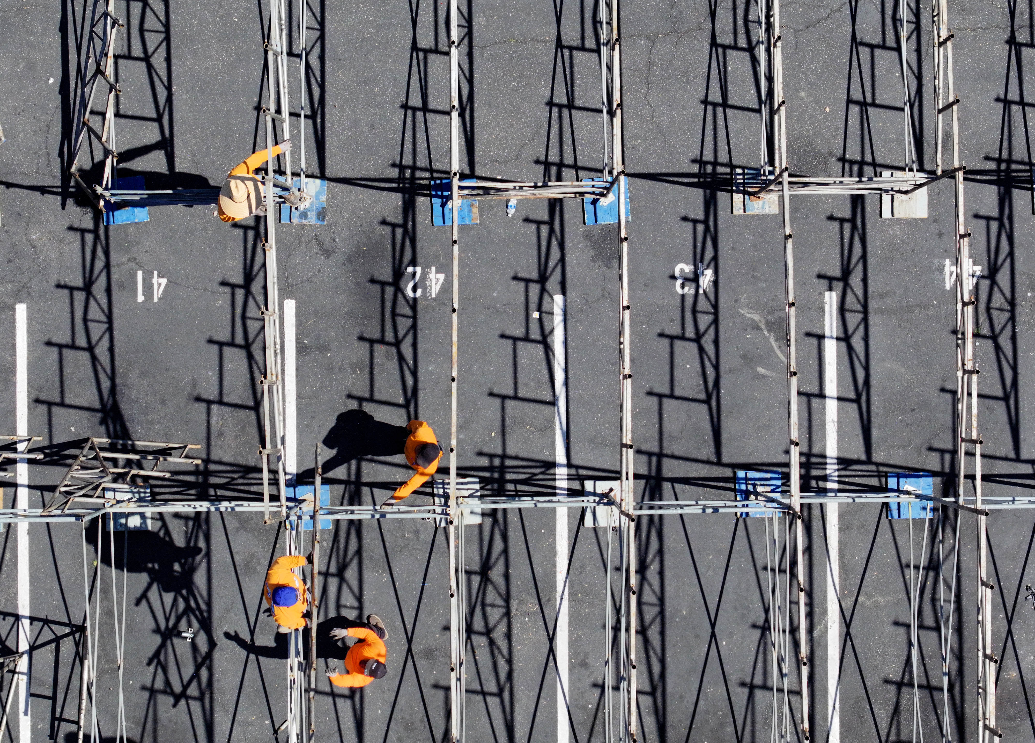 Workers dismantle grandstands in front of businesses along Shoreline Drive...