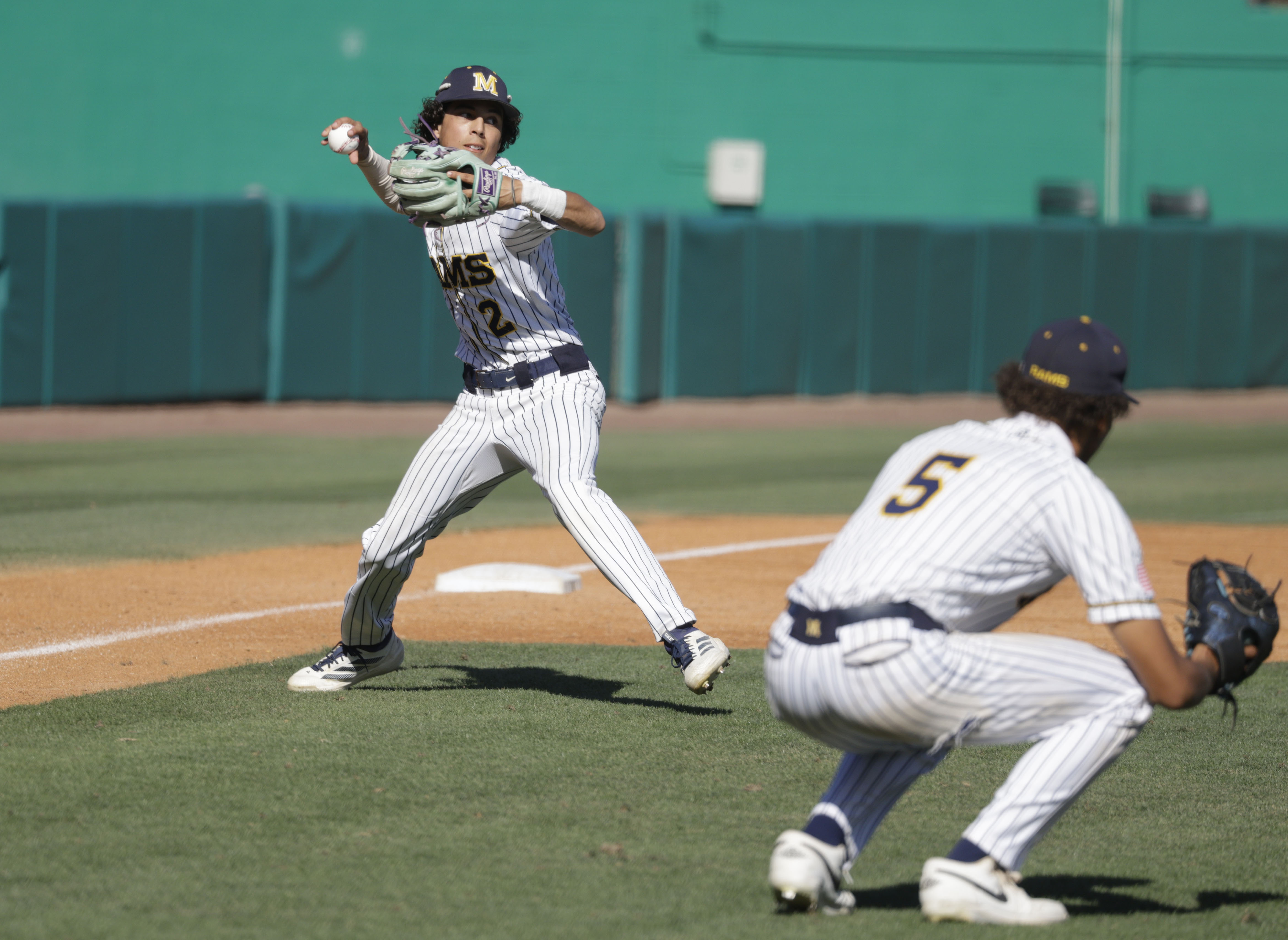 Millikan’s Ethan Barrientos (2) looks to get the out at...