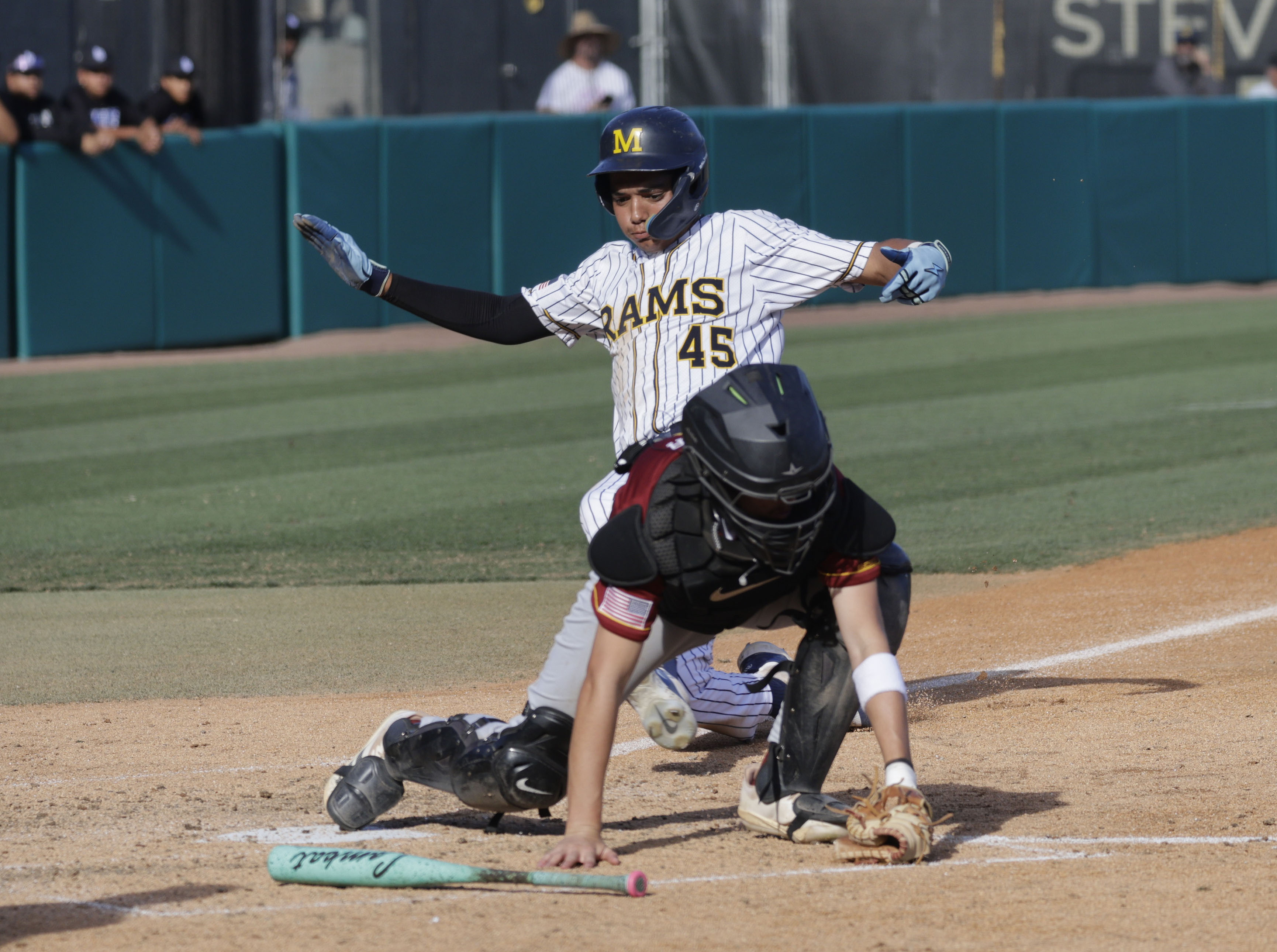 Millikan’s AJ Nonato slides into home as Wilsons Cade Miller...