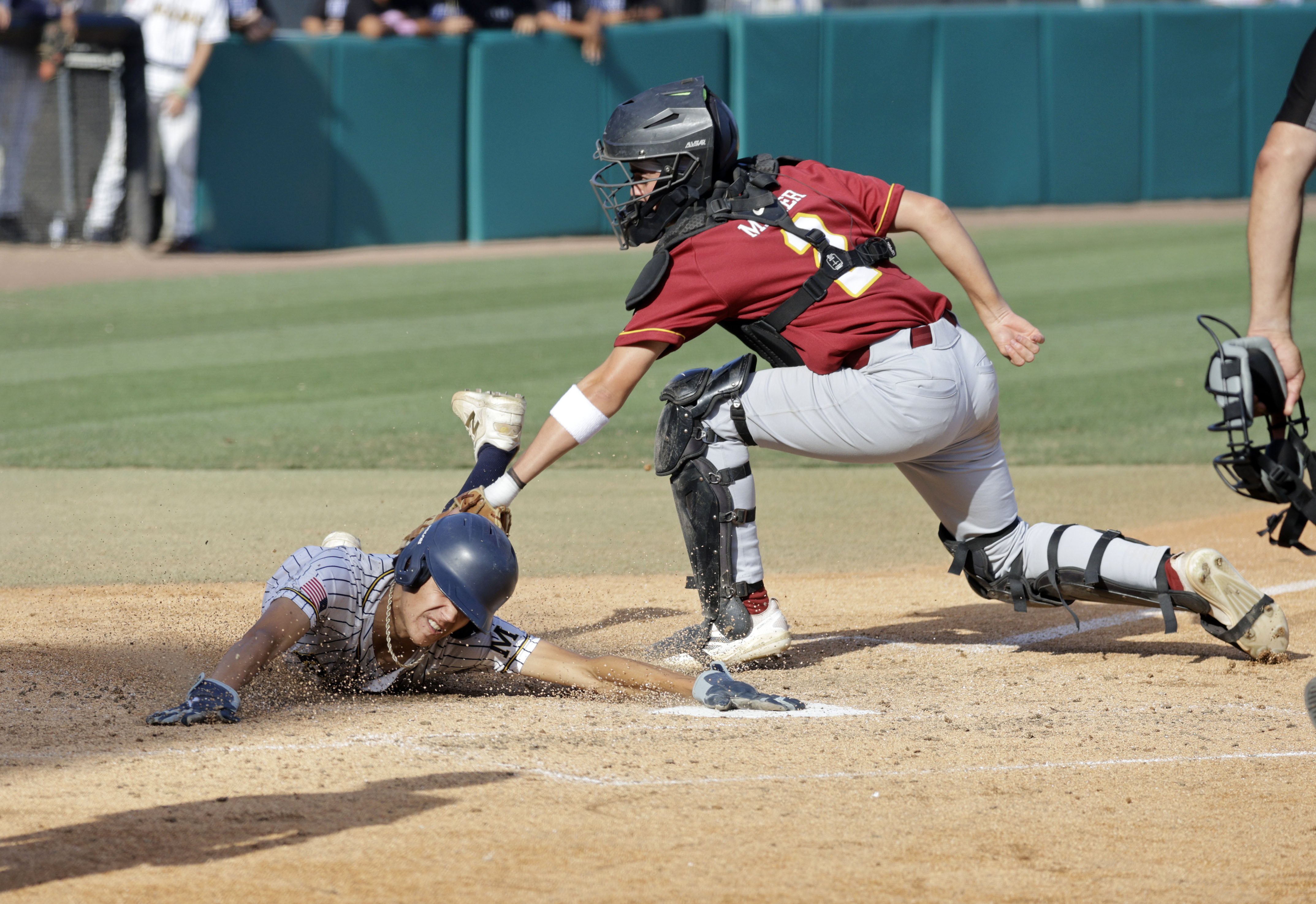 Wilson catcher Cade Miller (2) tries to tag out Millikan’s...