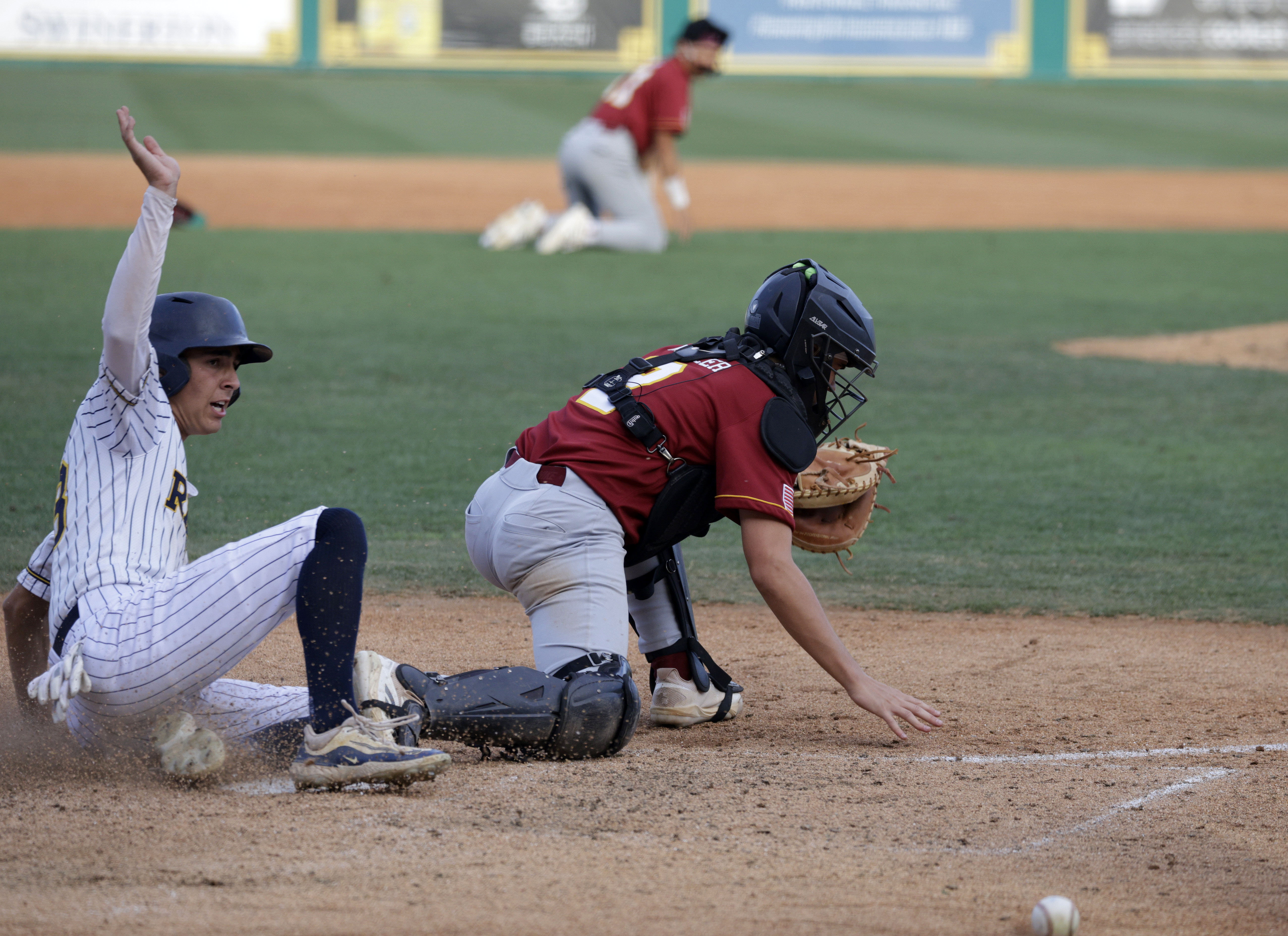 Wilson catcher Cade Miller (2) cant get the stop as...