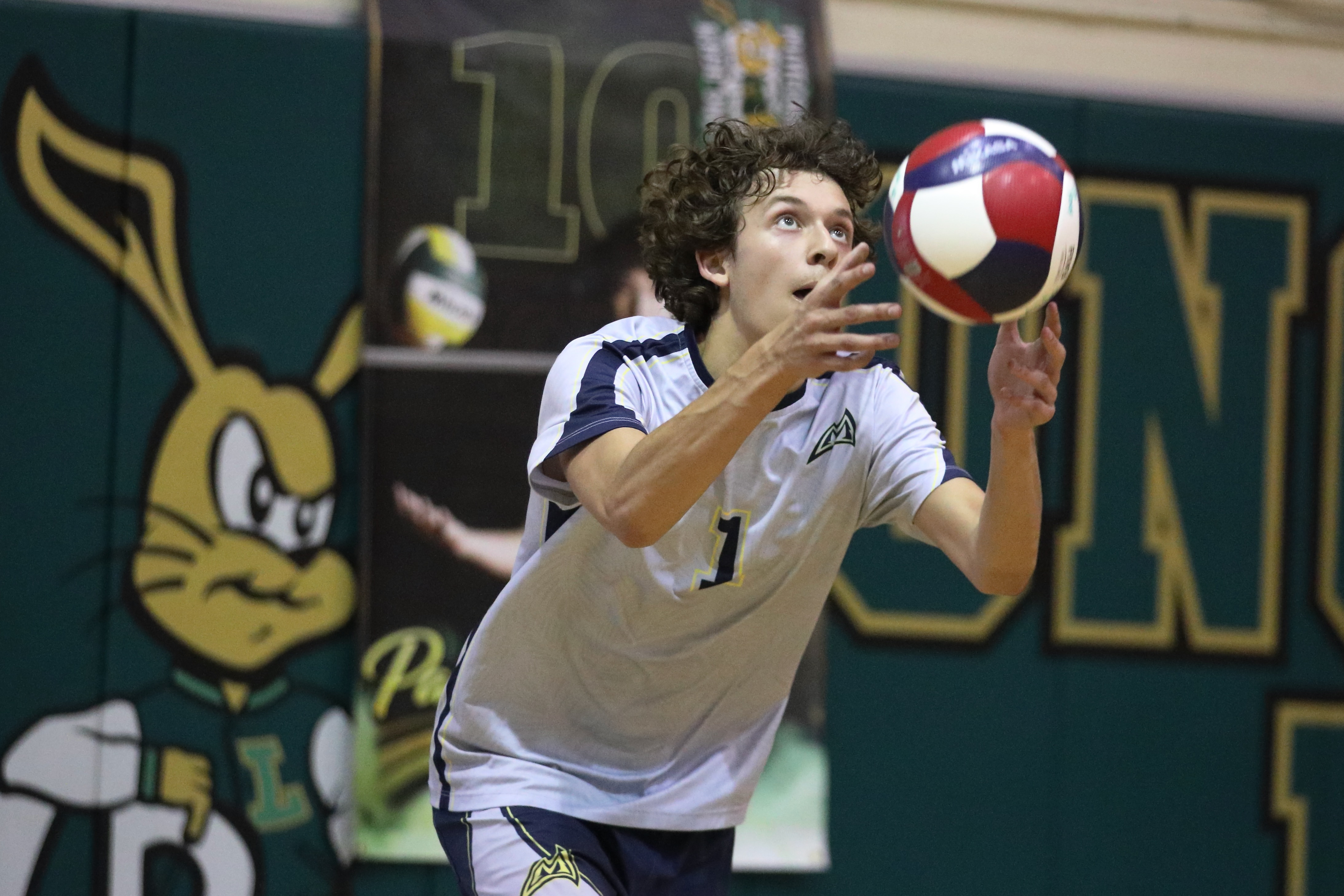 Millikan senior Jacob Karkanen serves against Poly in boys volleyball...