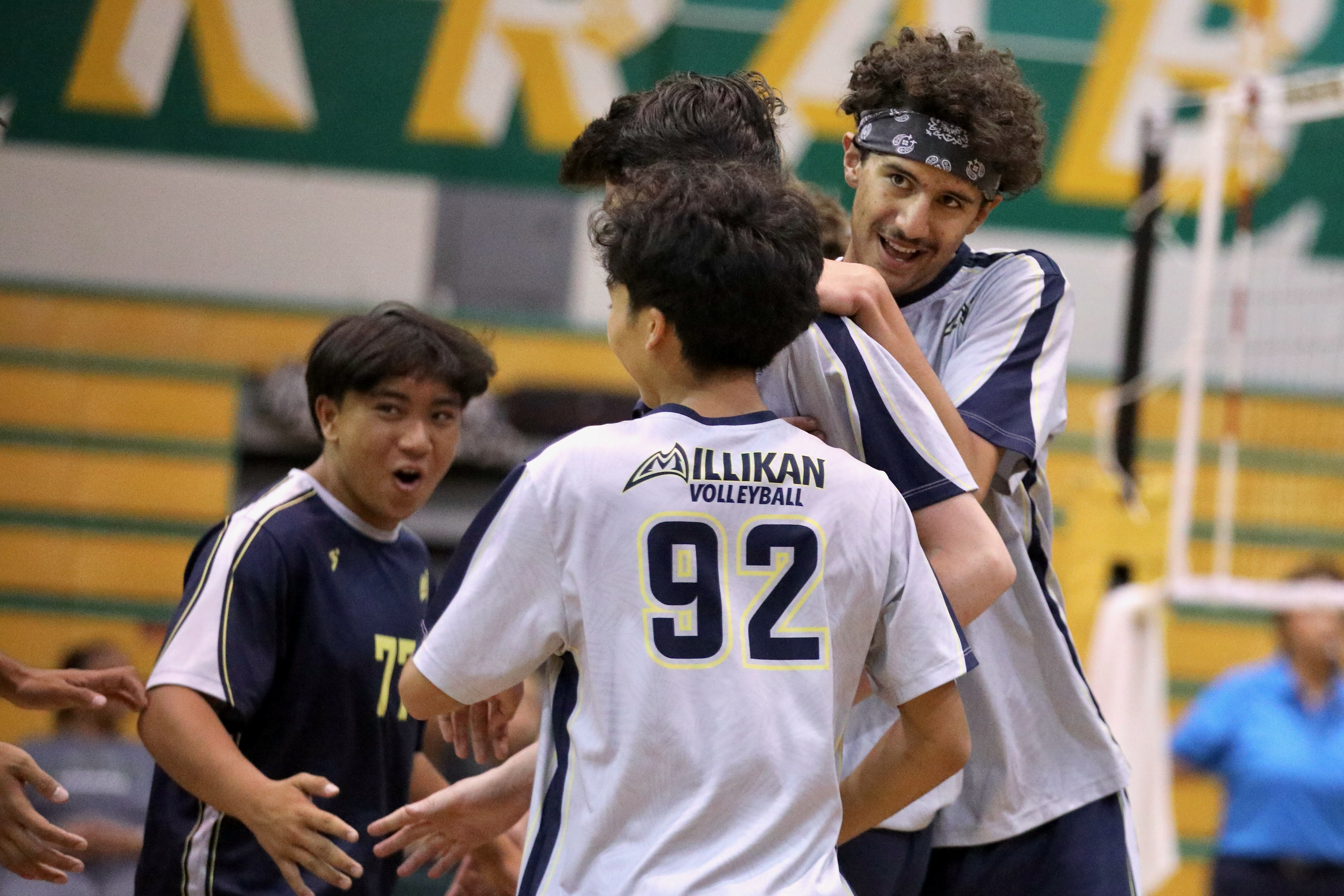 Millikan sophomore middle blocker Andre Medina, right, gets a hug...