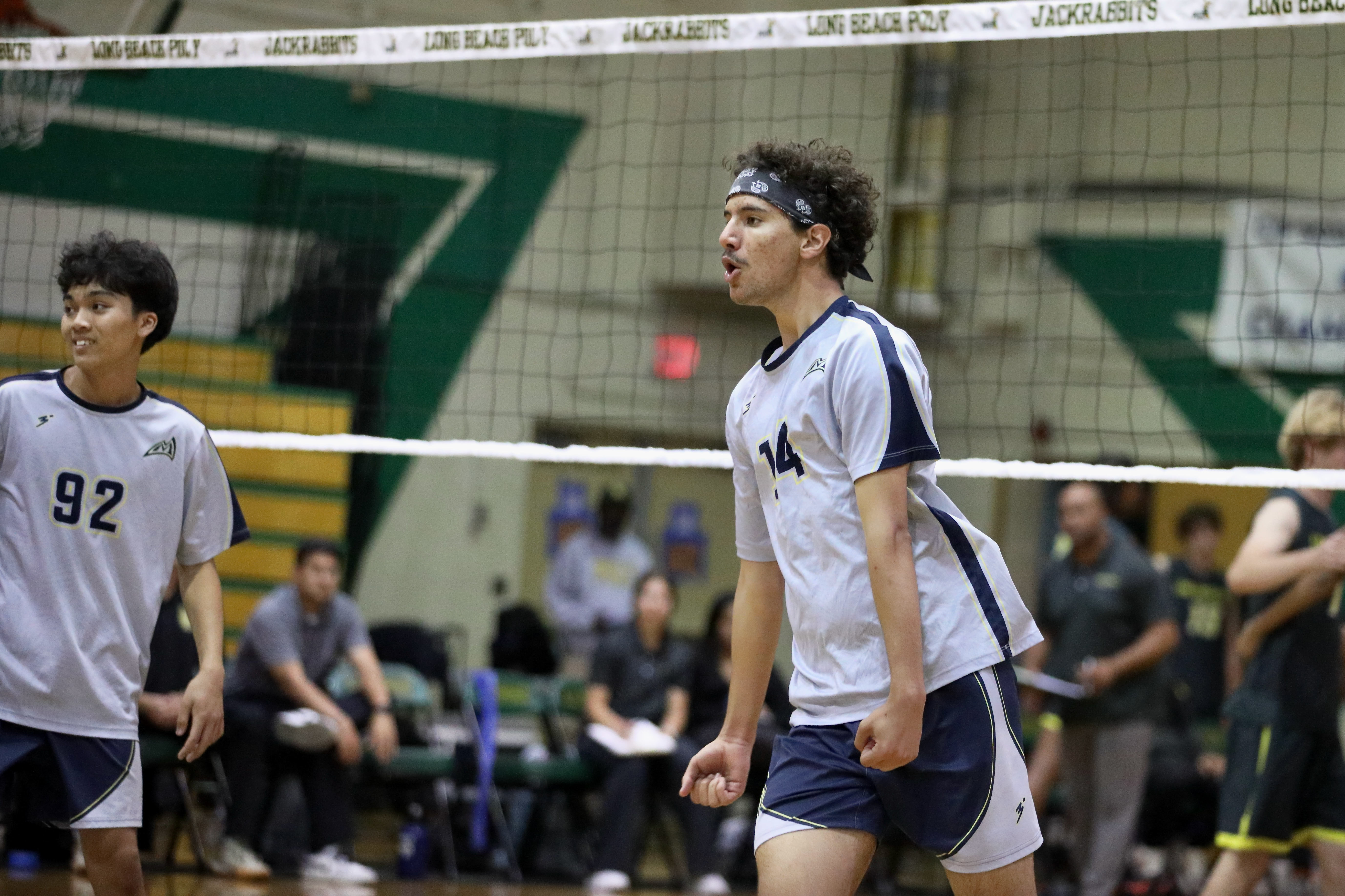 Millikan sophomore middle blocker Andre Medina clenches his fists after...