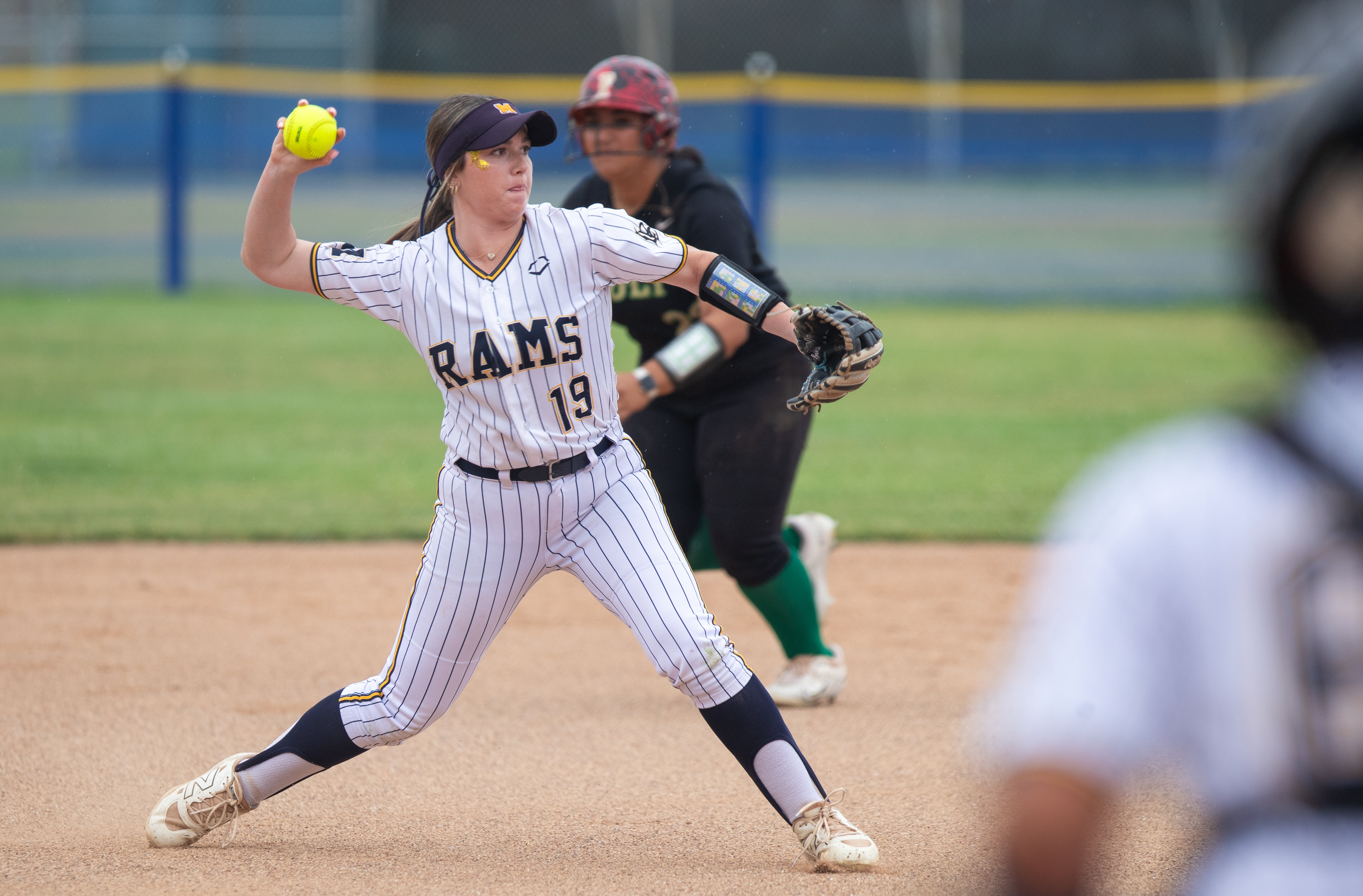 Millikanâs Addy Everett throws to first during a girlâs softball...