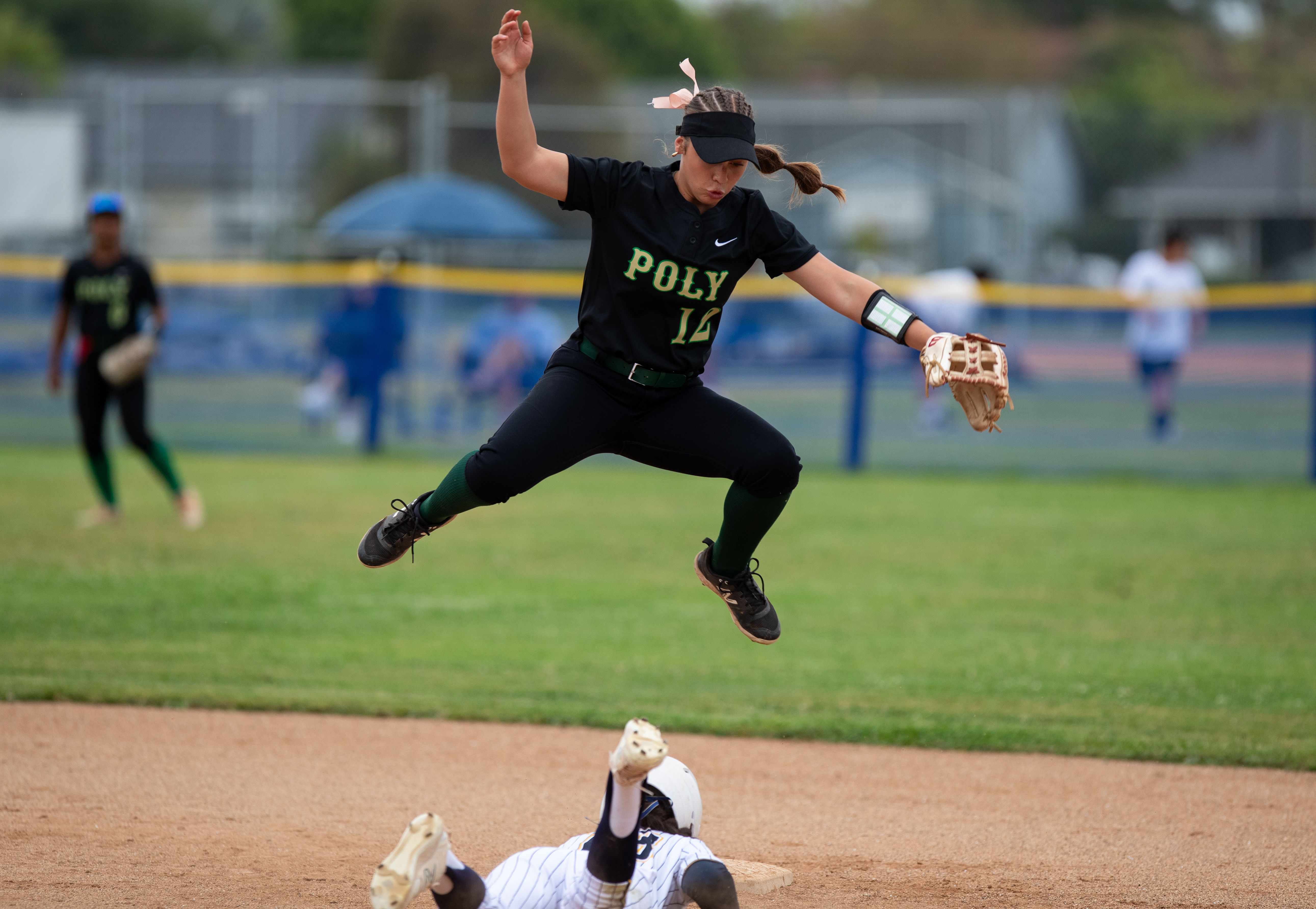 Long Beach Polyâs Bailey Holder leaps over Millikanâs Liana Lopez...
