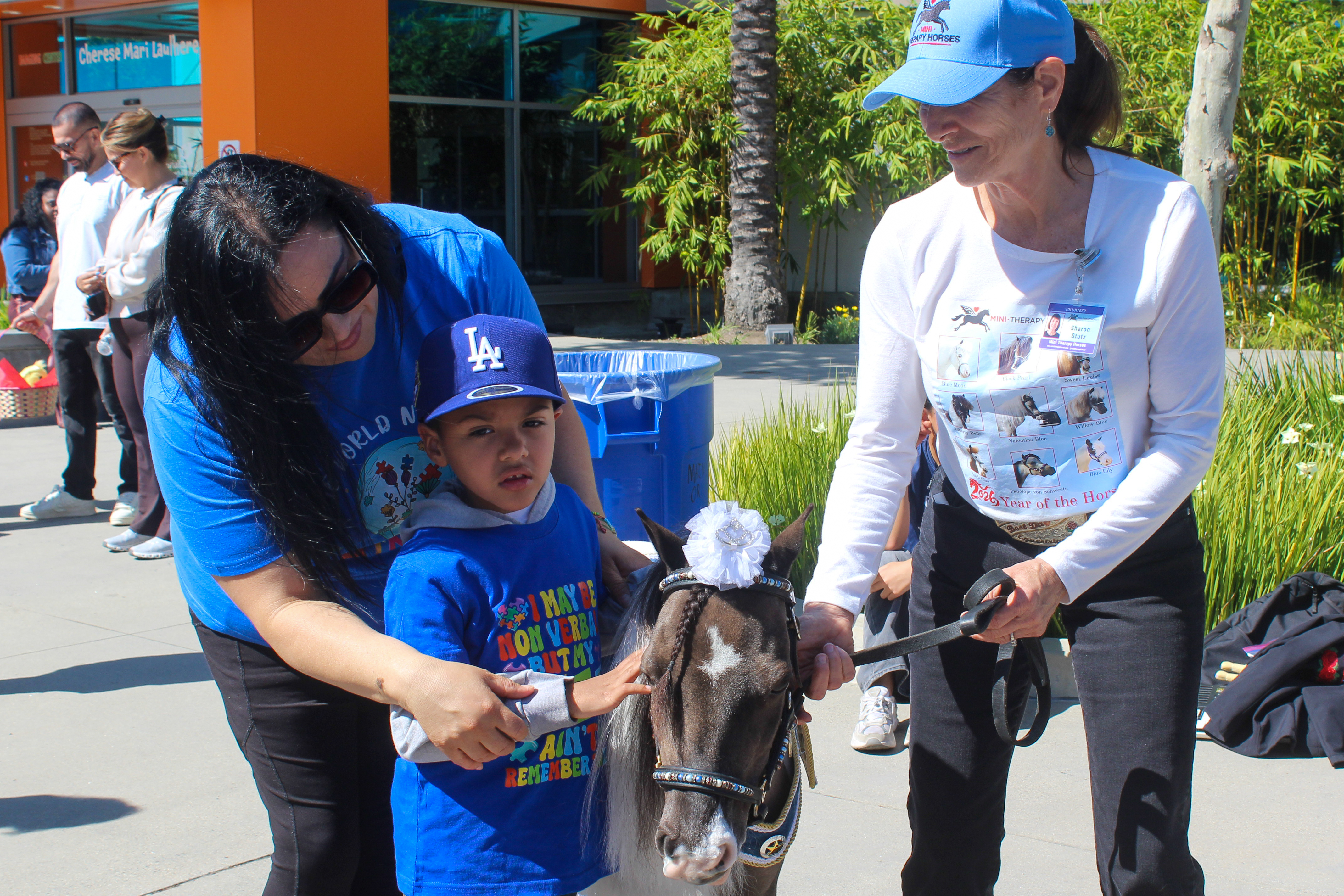 Children and families interacted with mini therapy horses at Miller...