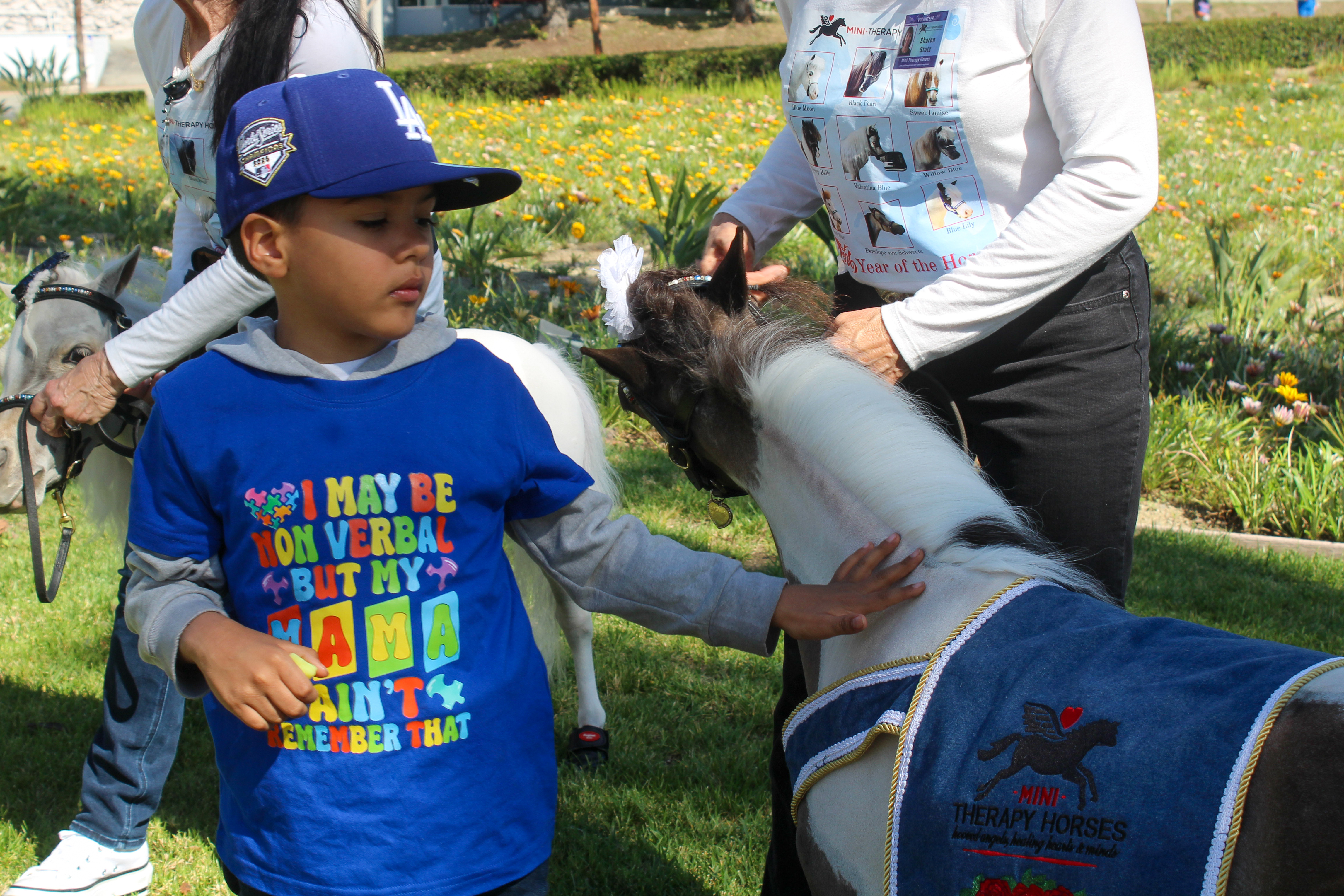Children and families interacted with mini therapy horses at Miller...