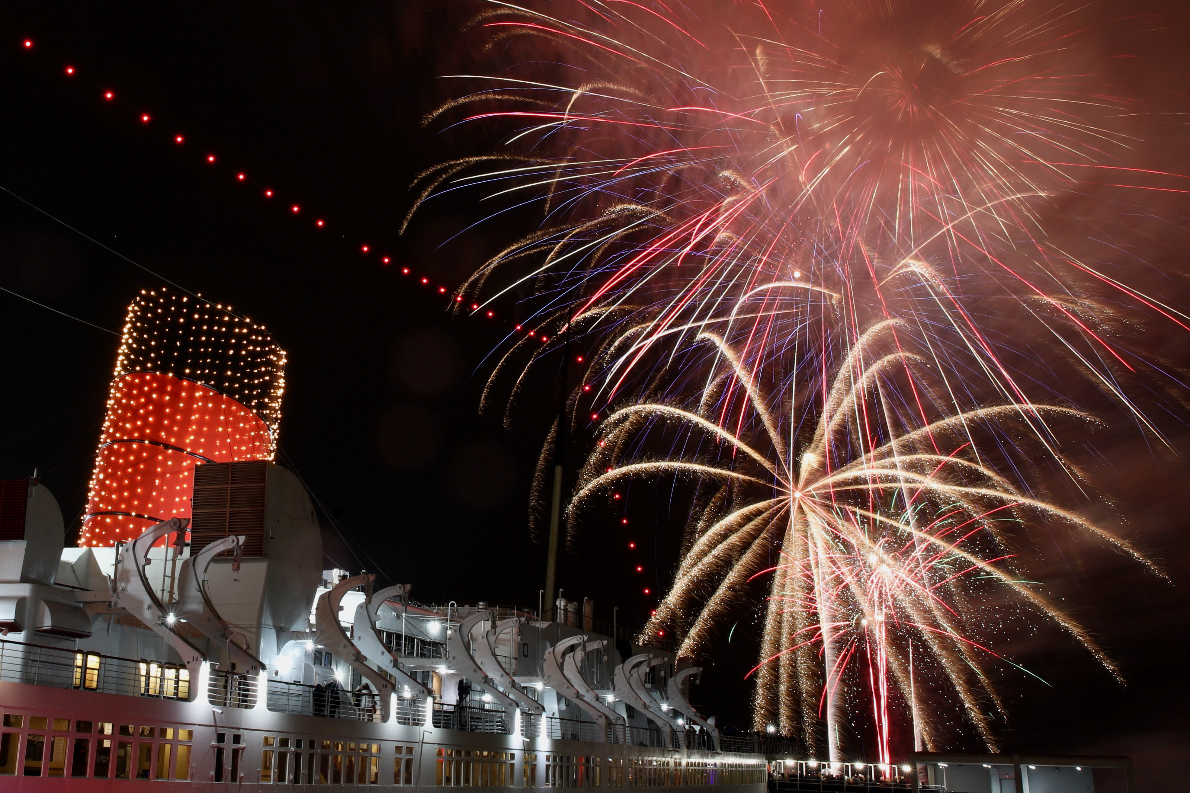 Fireworks light the sky over the Long Beach harbor at...