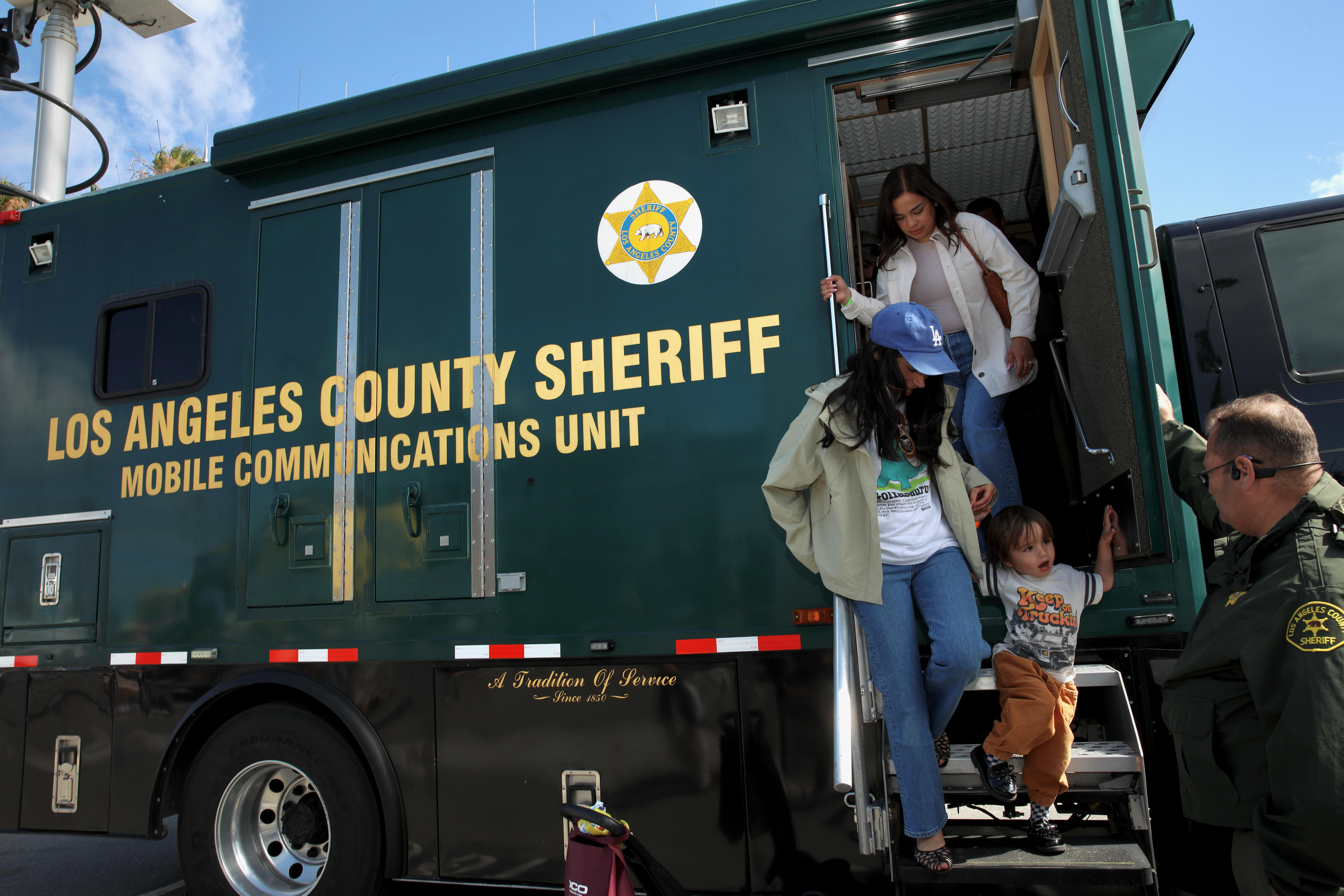 Attendees descend from an L.A. County Sheriff mobile communications truck...