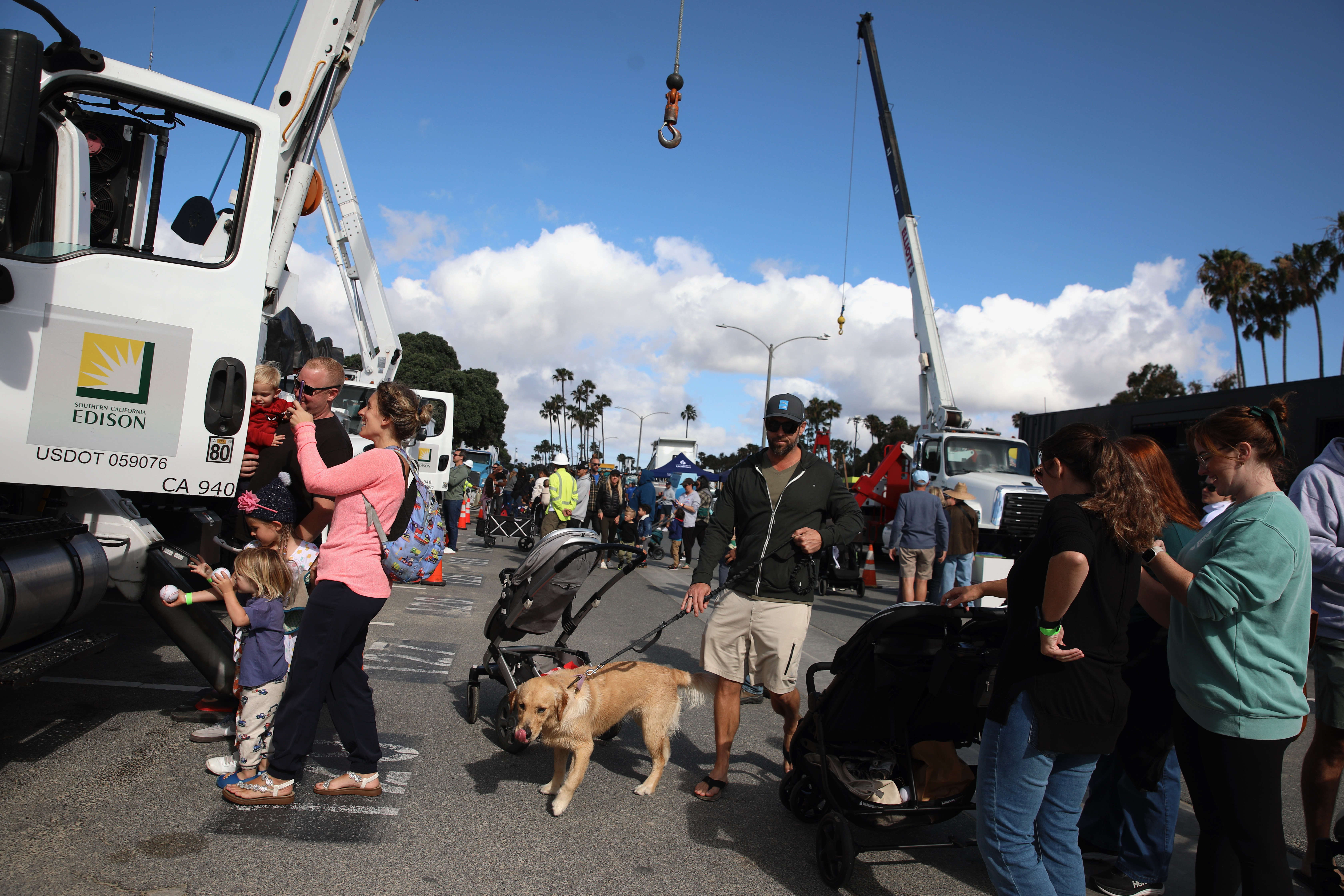 Visitors stroll past an array of trucks, safety and law...
