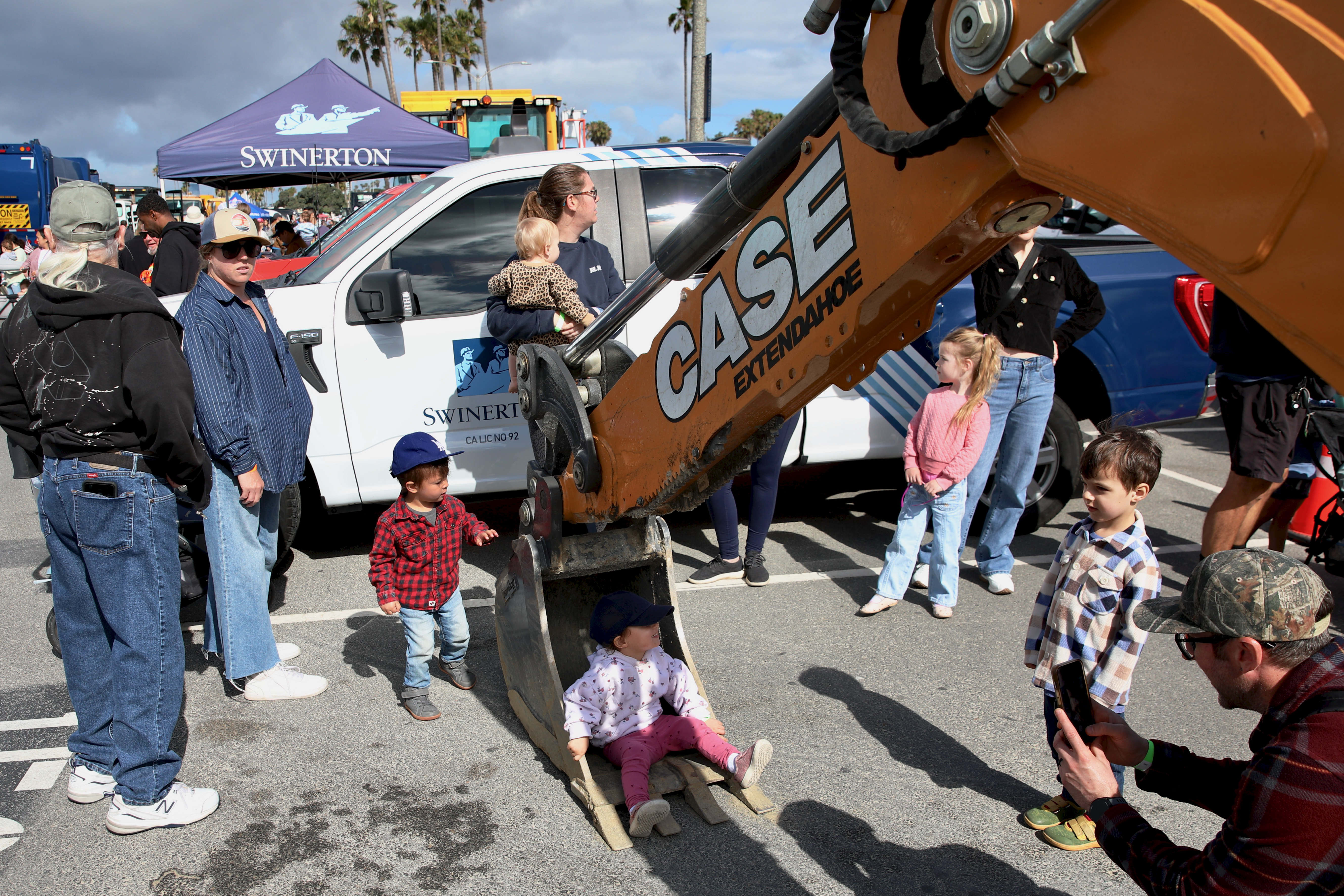 Families gather around an excavator at the annual Touch-A-Truck on...