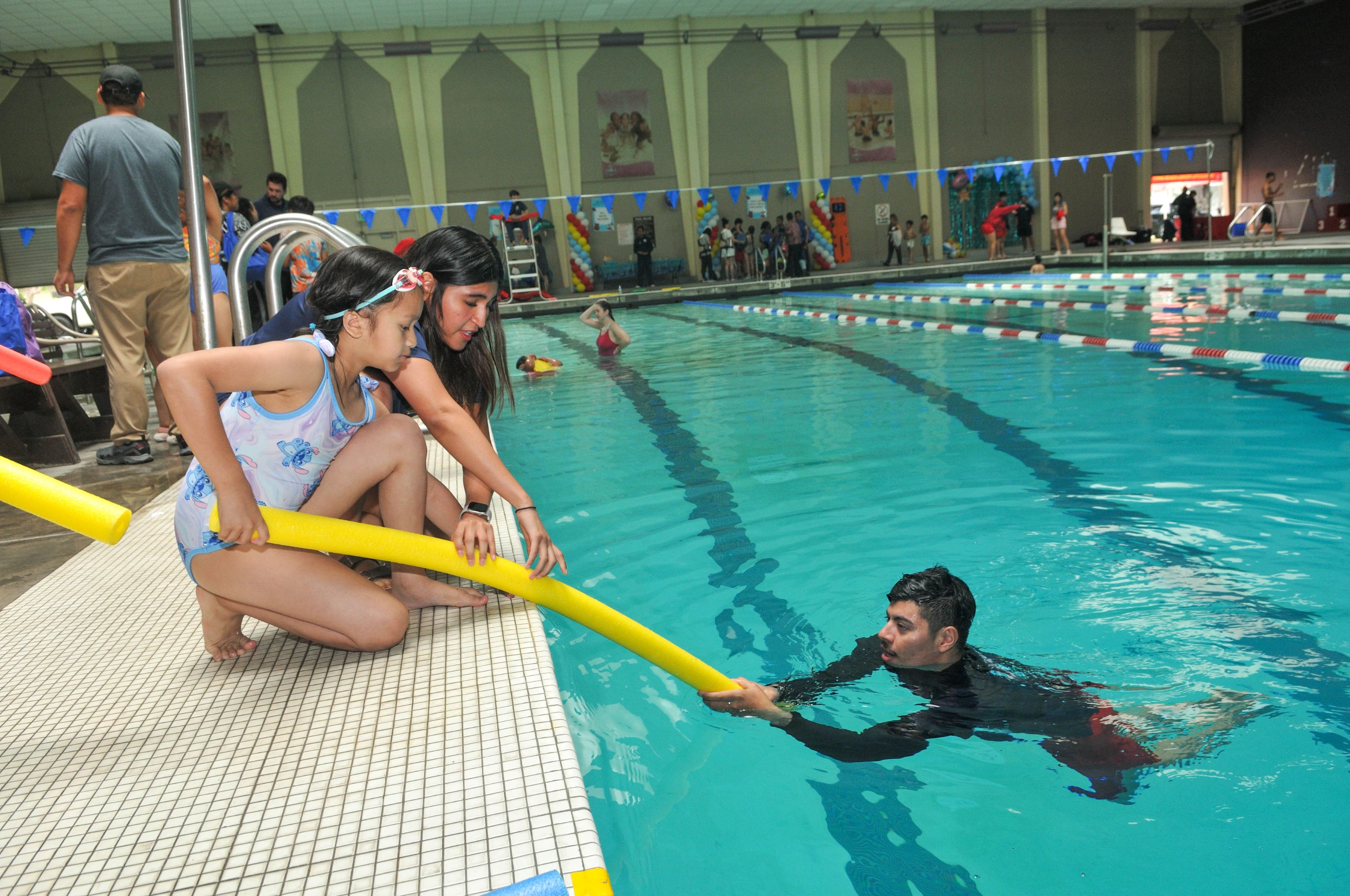Children practice life-saving skills and learn water safety tips during...