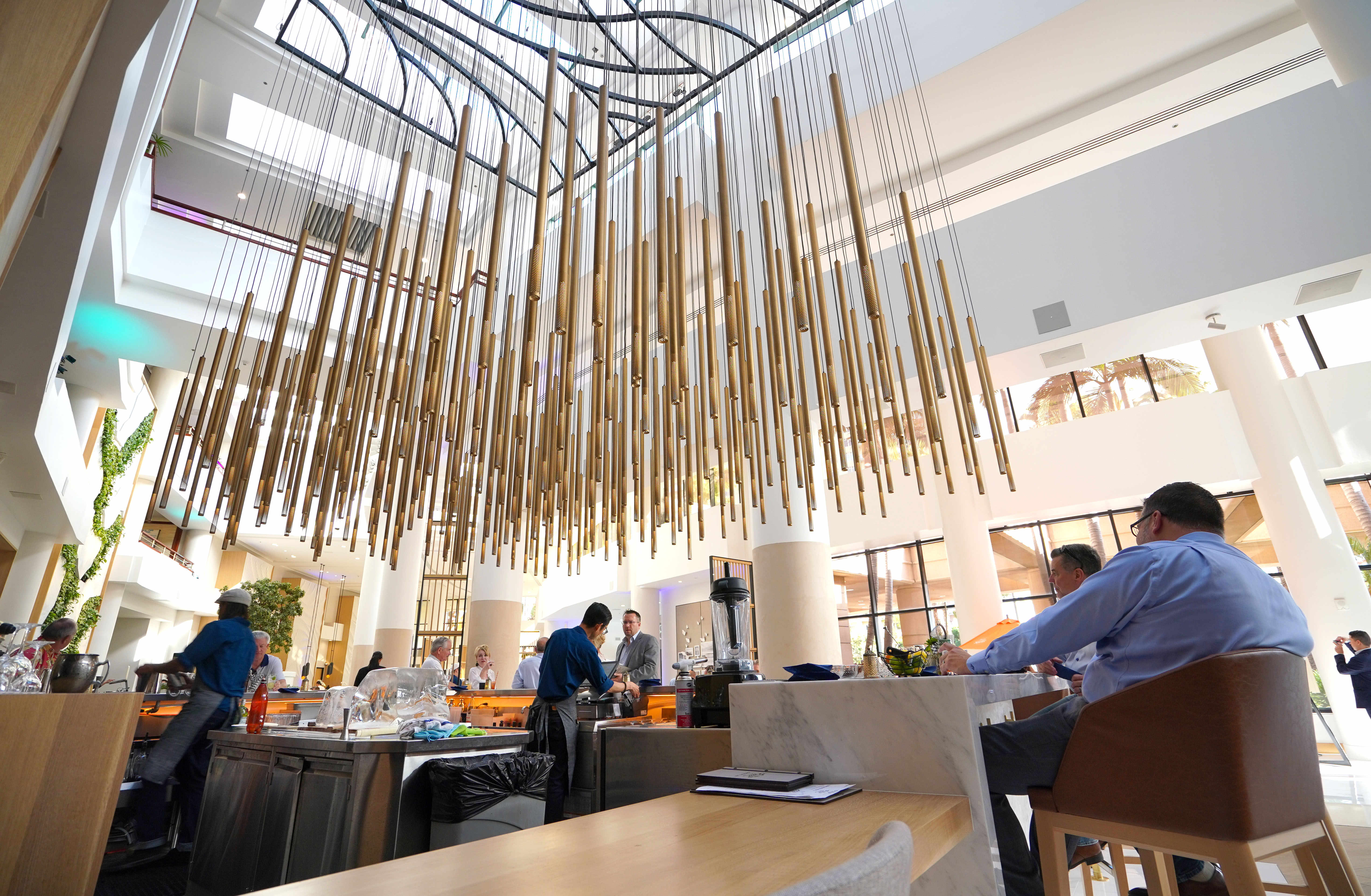 Guests sit under a large hanging sculpture at the new...
