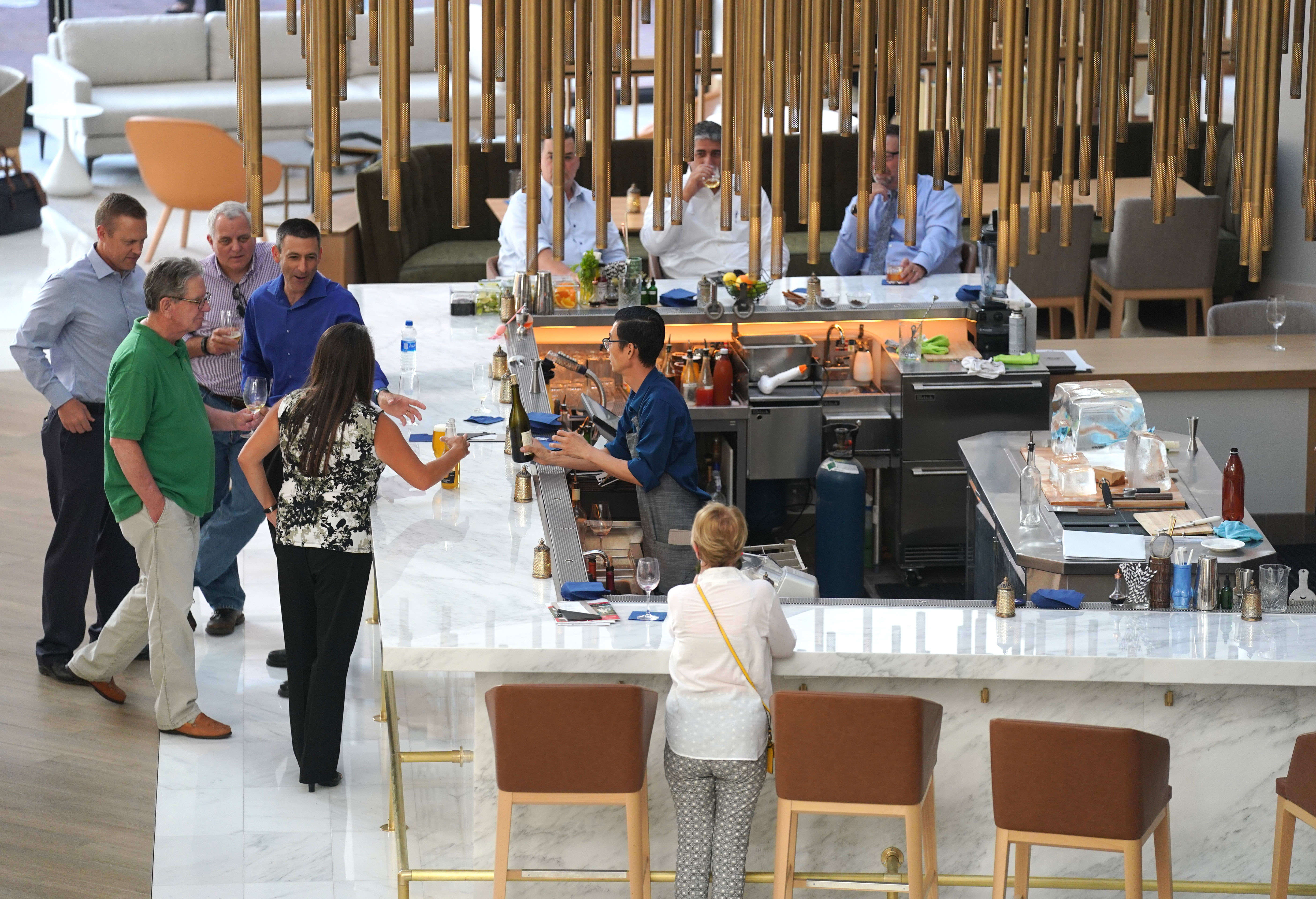 Guests sit under a large hanging sculpture at the new...