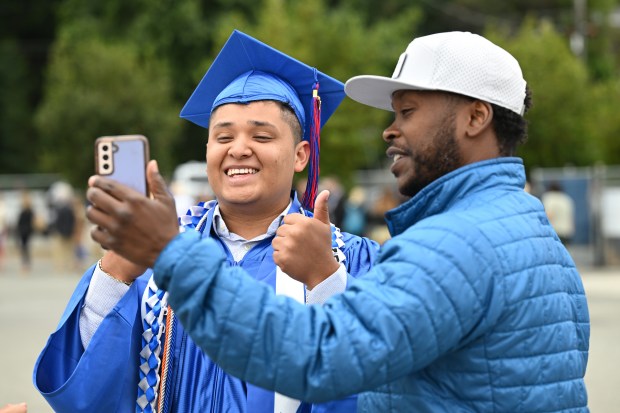 Kenneth Fuentes, 17, of Marin City takes a photo with Rondell Gibson, director of the Bridge the Gap program at Tamalpais High School, before graduation at the campus in Mill Valley, Calif., on Thursday, June 13, 2024. Fuentes, who was supported by Bridge the Gap, graduated a year early. (Sherry LaVars/Marin Independent Journal)