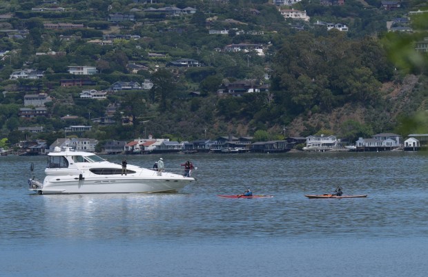 Kayakers cross paths with a boat on Richardson Bay near the Sausalito waterfront on Wednesday, April 15, 2026. The bay has been cleared of nearly all the vessels where people had lived offshore. (Sherry LaVars/Marin Independent Journal)