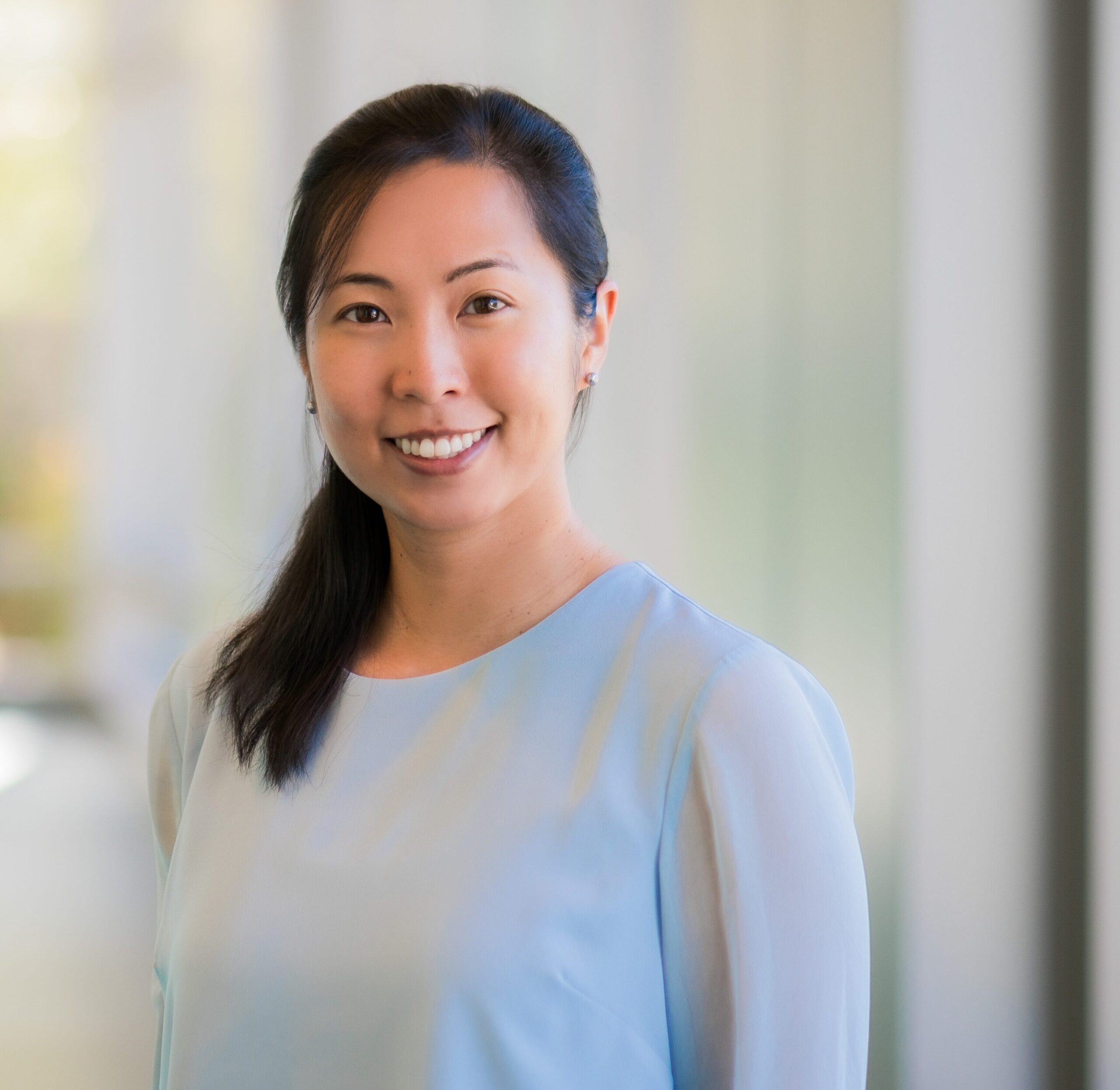 Dr. Maggie Chung stands before a window