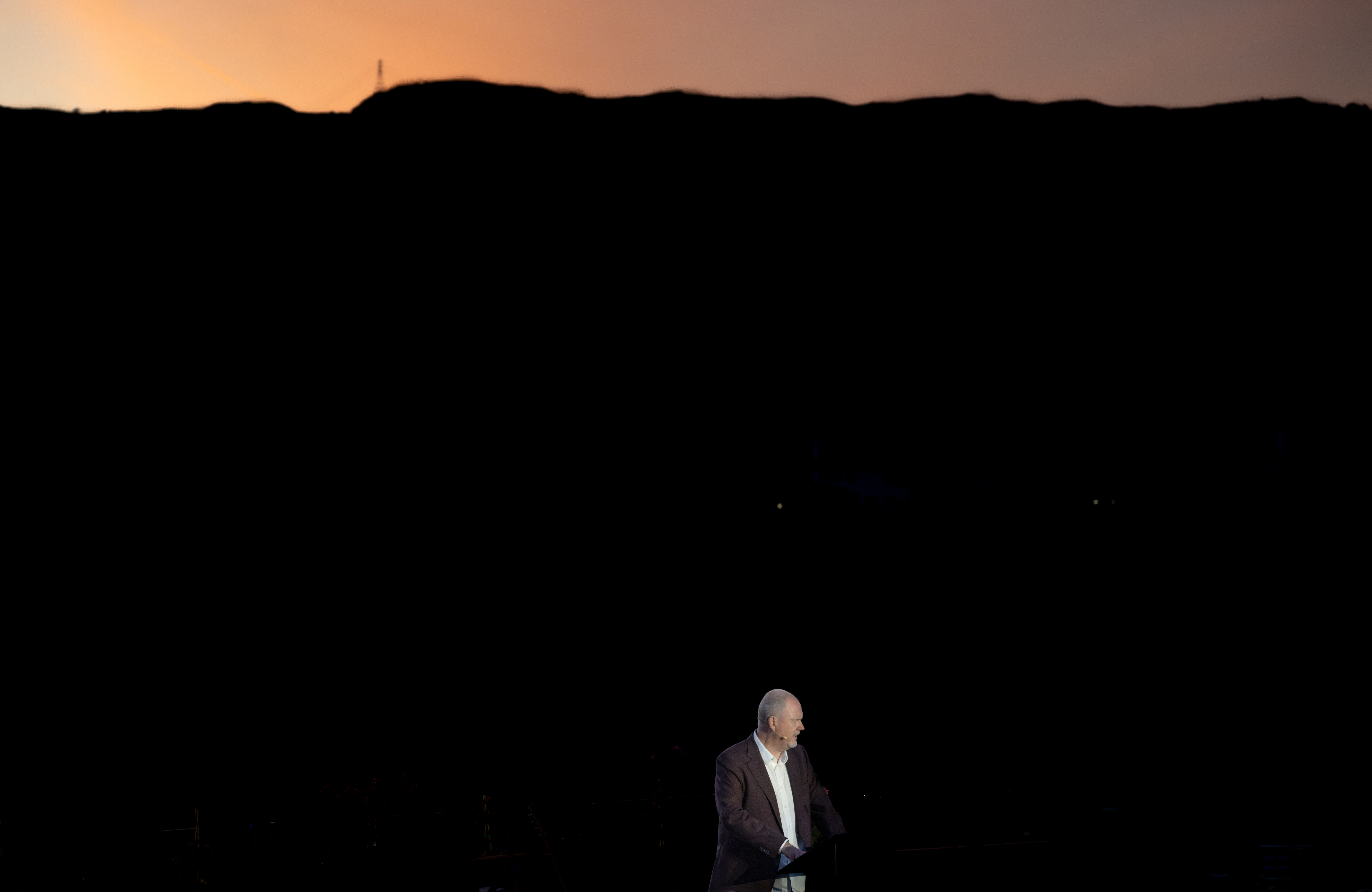 The sky turns orange above Philip De Courcy, senior pastor...
