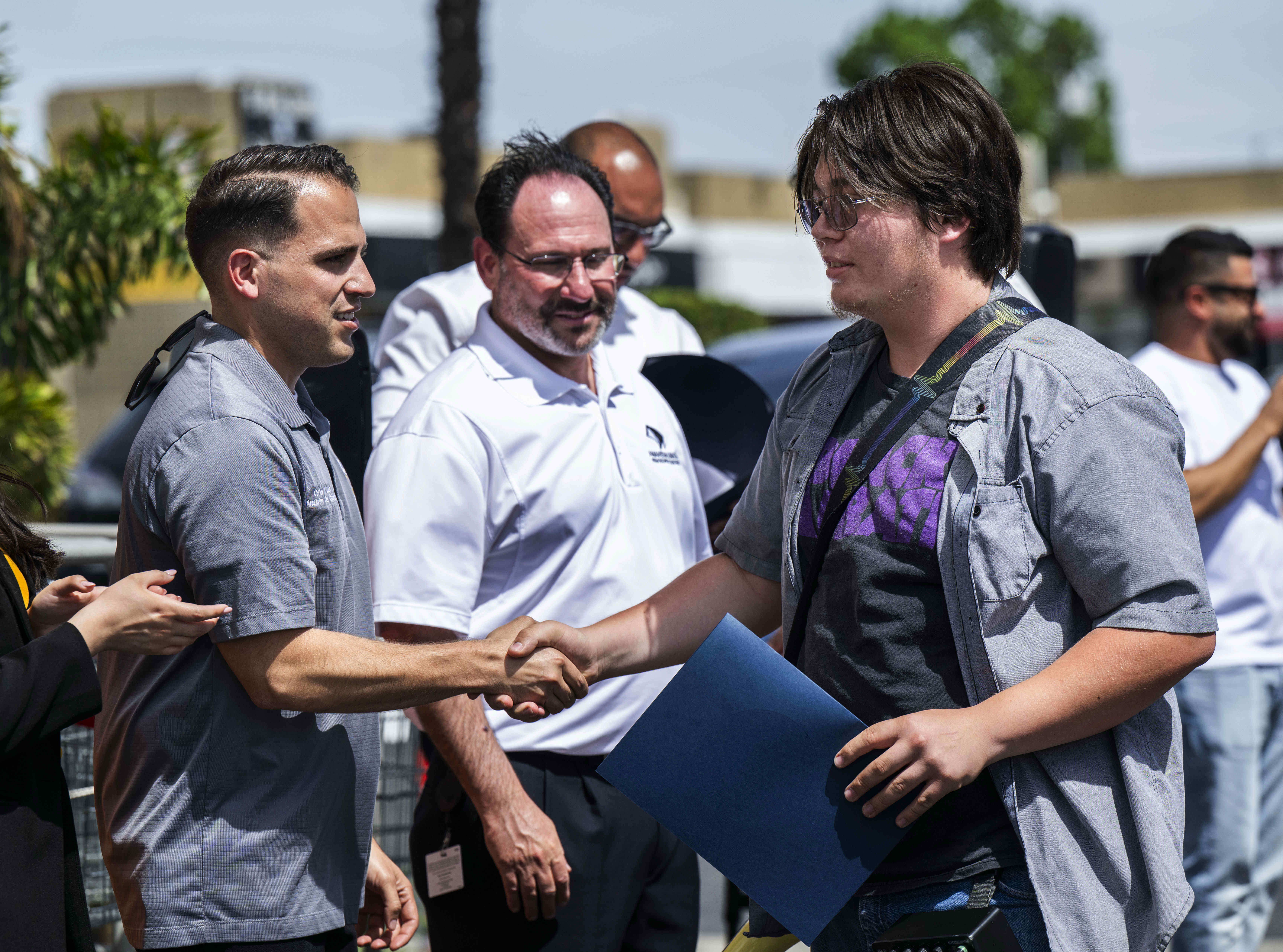 Gabriel Macias-Islas, right, is congratulated by Carlos Leon, Anaheim City...