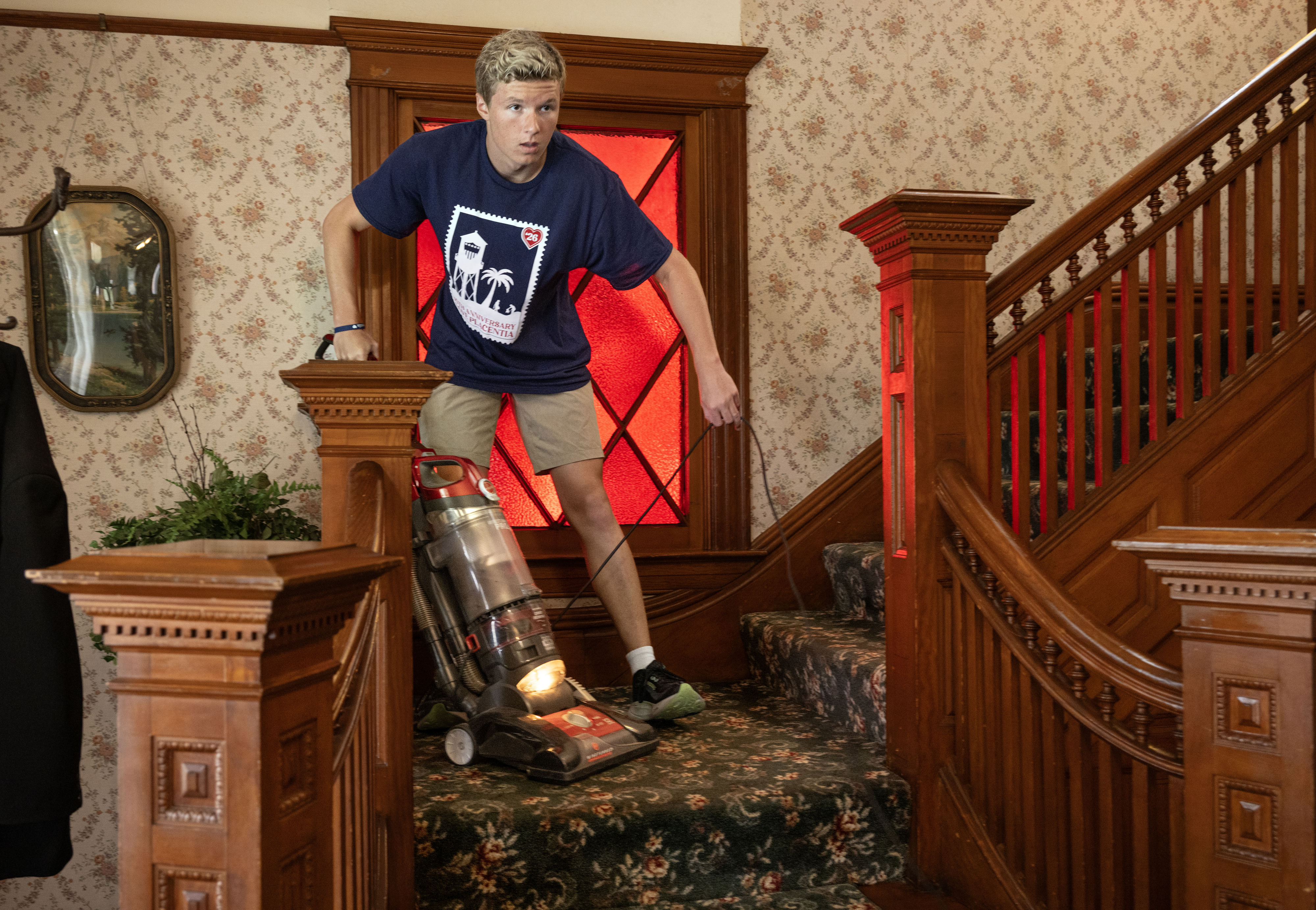 Tyler Shultz vacuums the stairs inside the historic Bradford House...