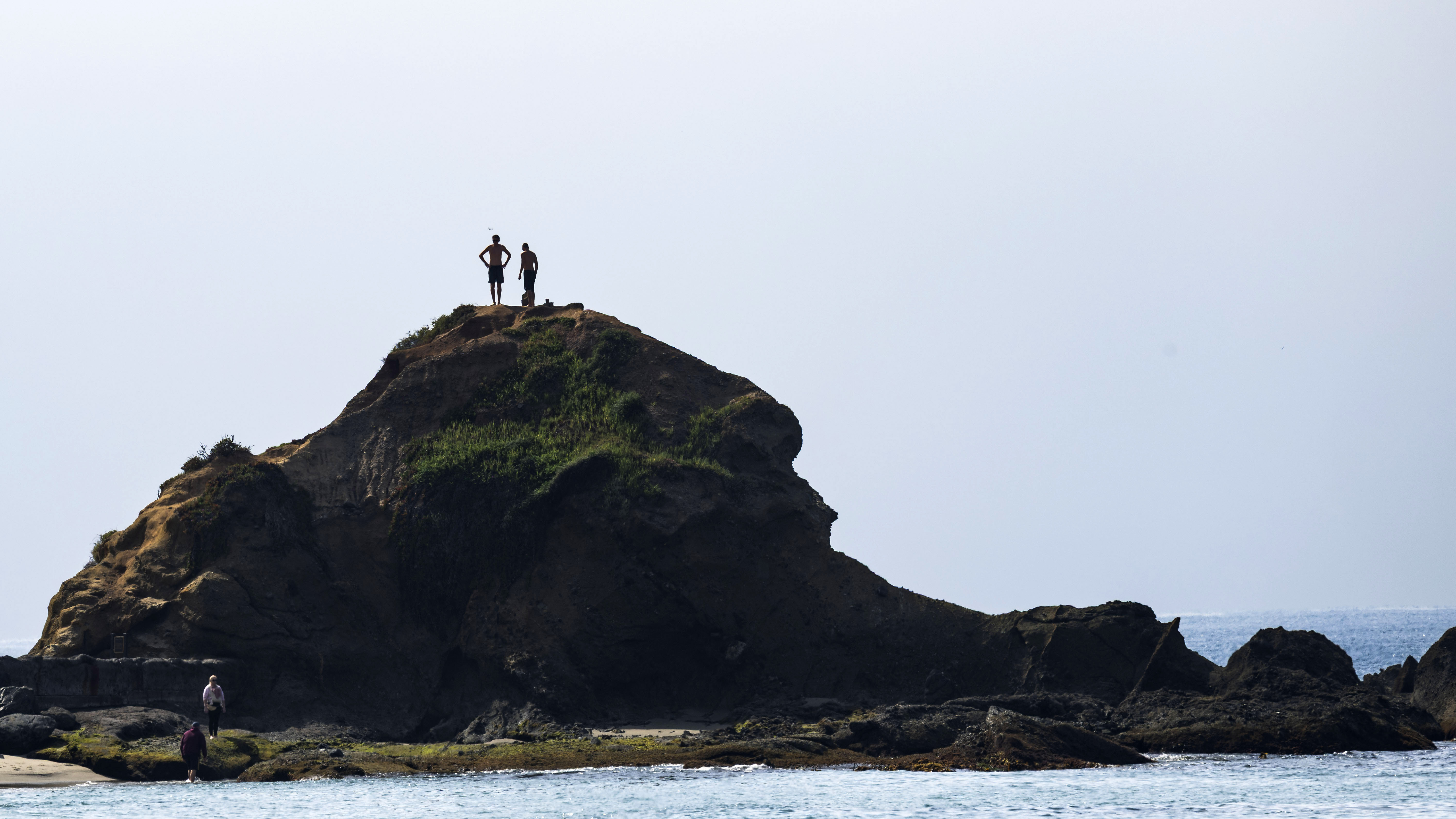 Two people stand atop Goff Island in south Laguna Beach,...