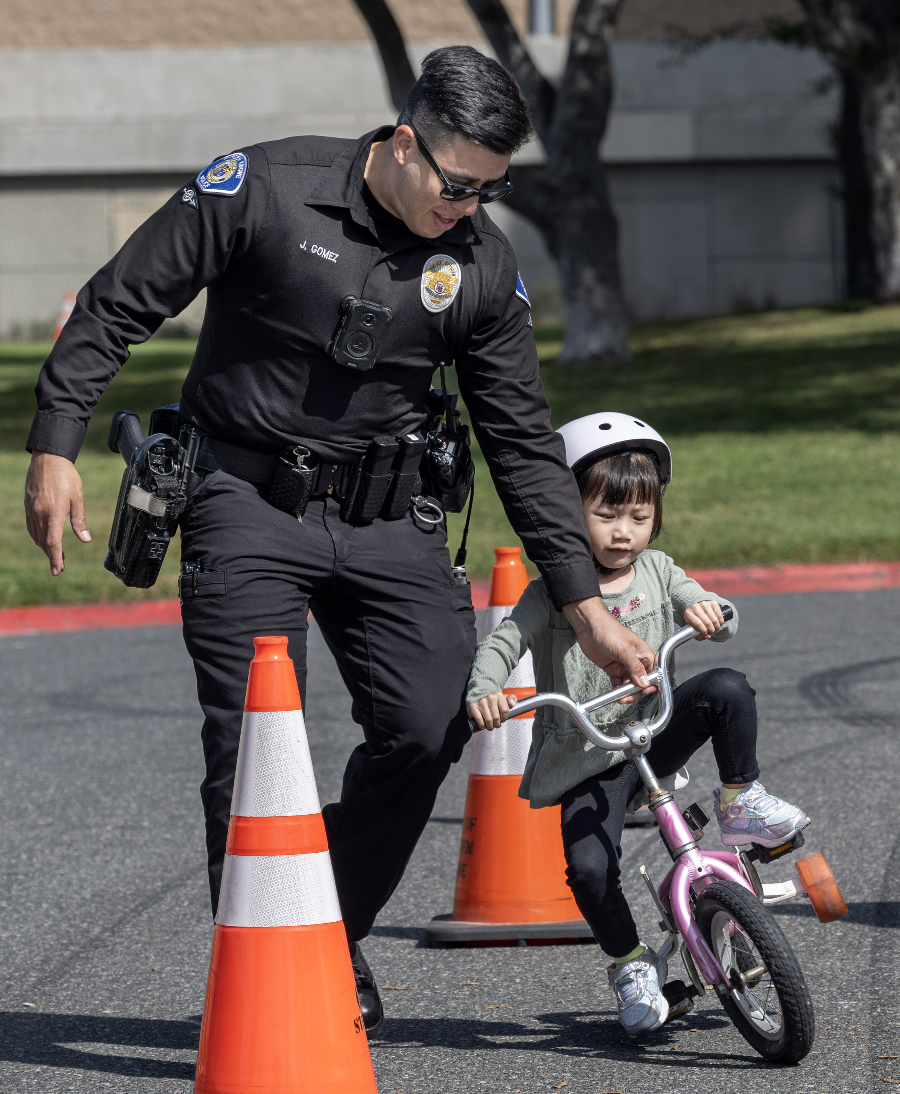 Garden Grove Police officer Jesus Gomez helps 3-year-old Evelyn Vu...