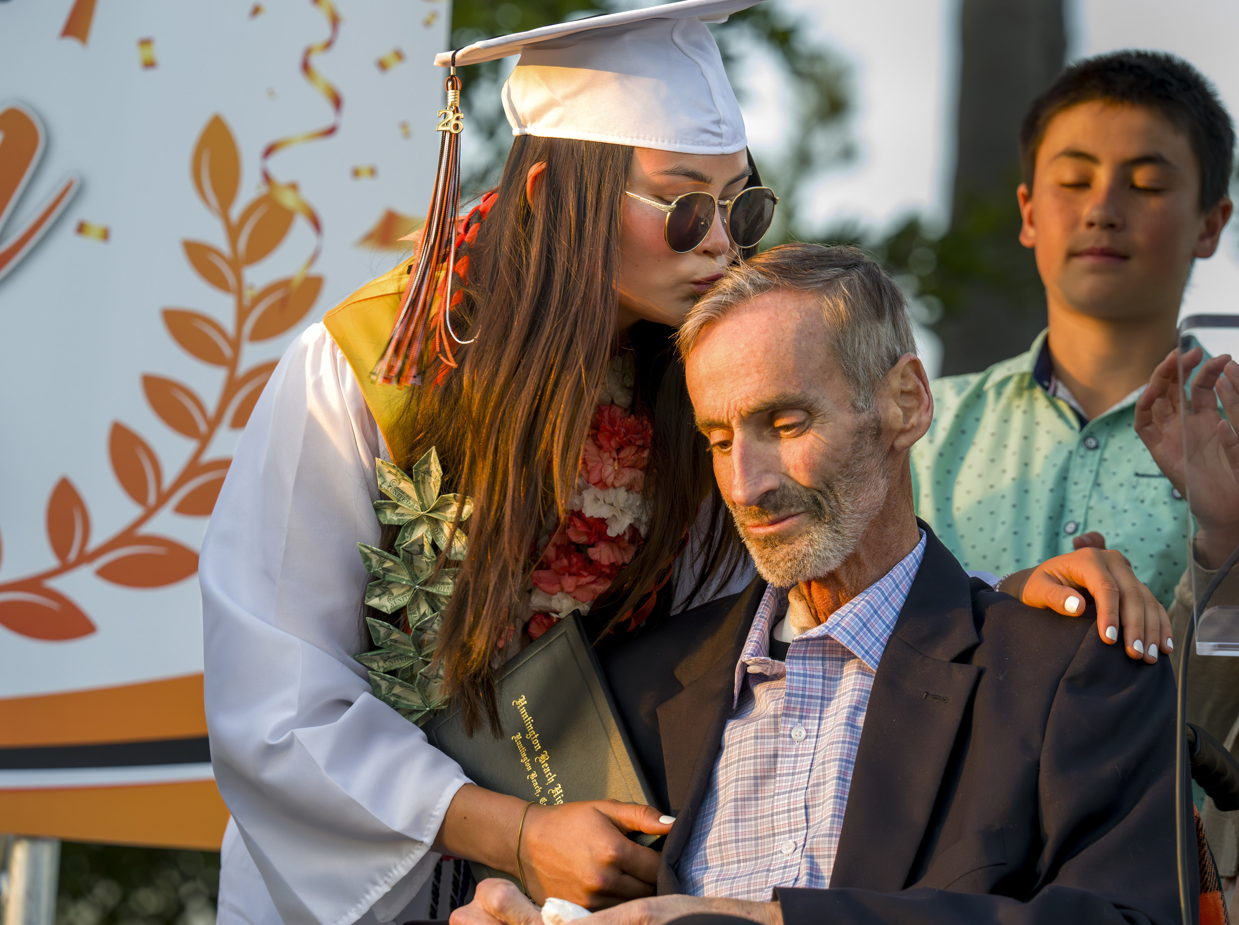 Huntington Beach High School senior Abbi Kerwin, left, kisses her...