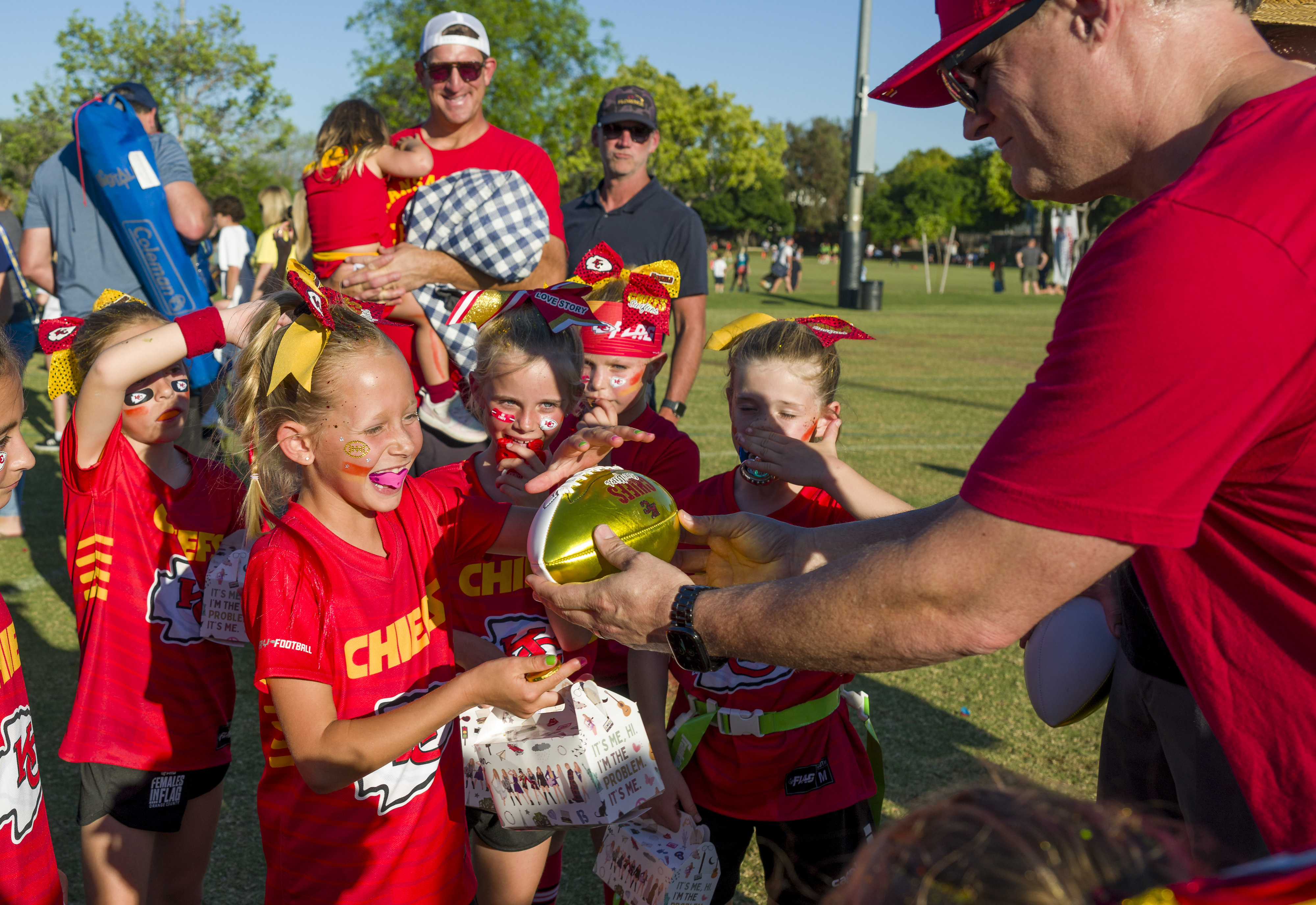 KC Chiefs coach Aaron Maher, right, hands âKC Swiftiesâ player...