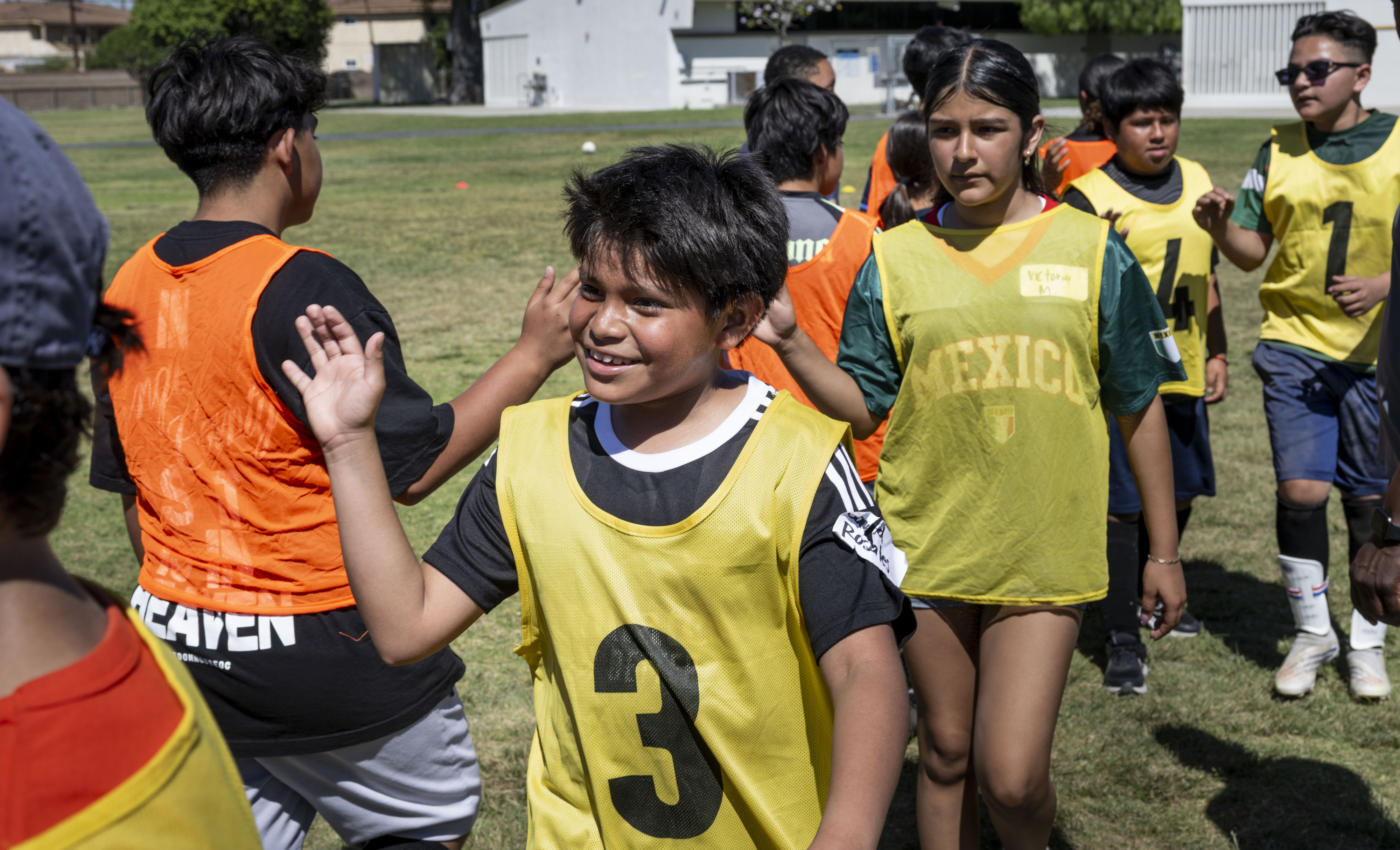 Kids run each other after a soccer game at a...