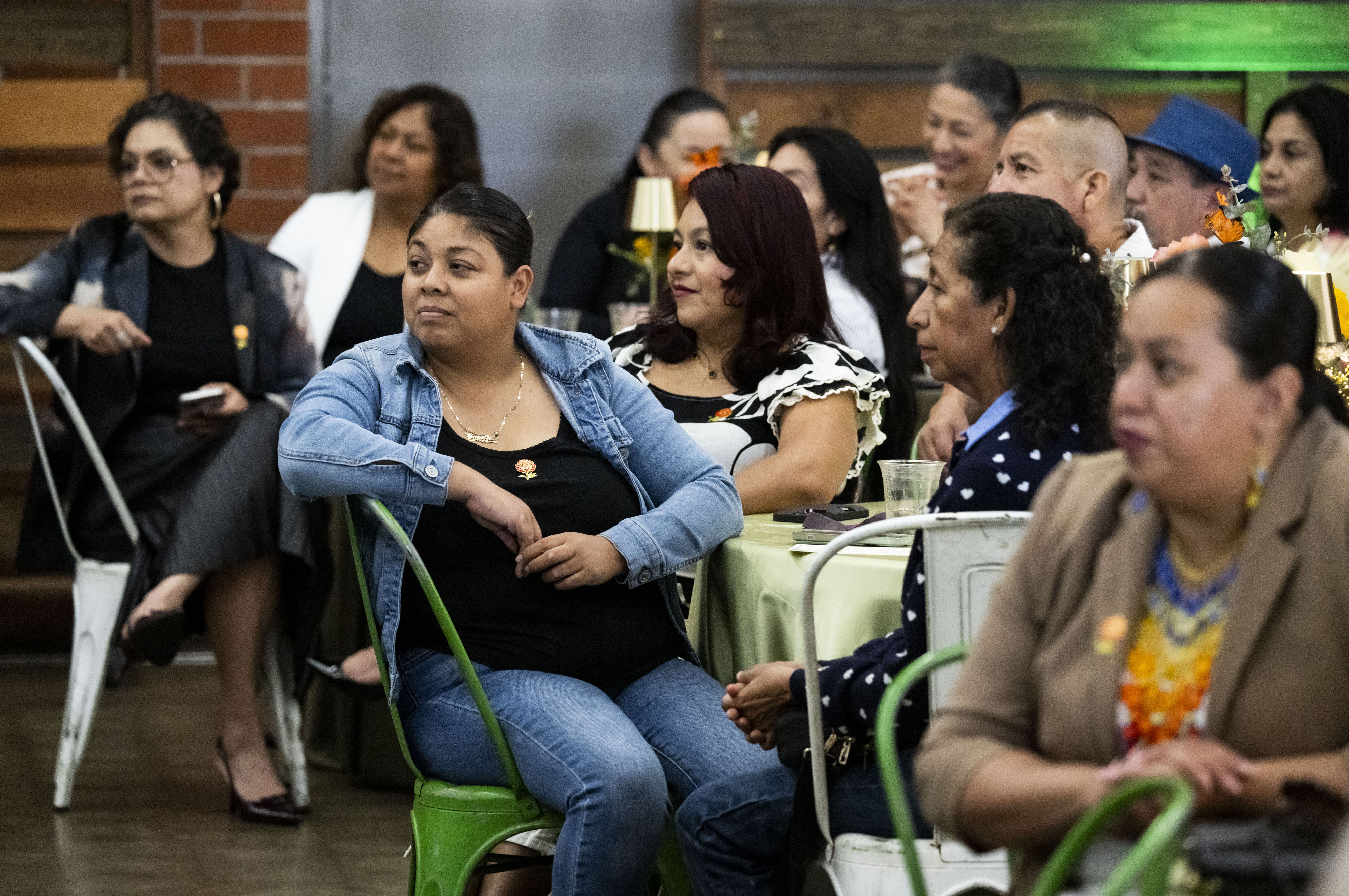 People listen to speakers during the Office of Immigrant and...