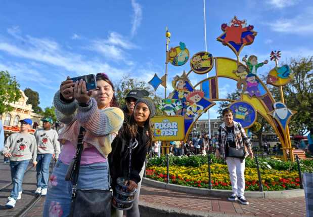Xochitl Velasco takes a selfie with her kids, Jade Robles and Maxx Robles, at the Pixar Fest monument inside Disnyeland in Anaheim, CA, on Wednesday, April 24, 2024. (Photo by Jeff Gritchen, Orange County Register/SCNG)