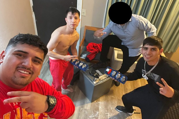 Three men allegedly involved in a Chilean burglary ring that targeted professional athletes pose with a collection of watches and a safe reportedly taken from the home of Milwaukee Bucks player Bobby Portis. (Courtesy of U.S. Attorney's Office, Middle District of Florida