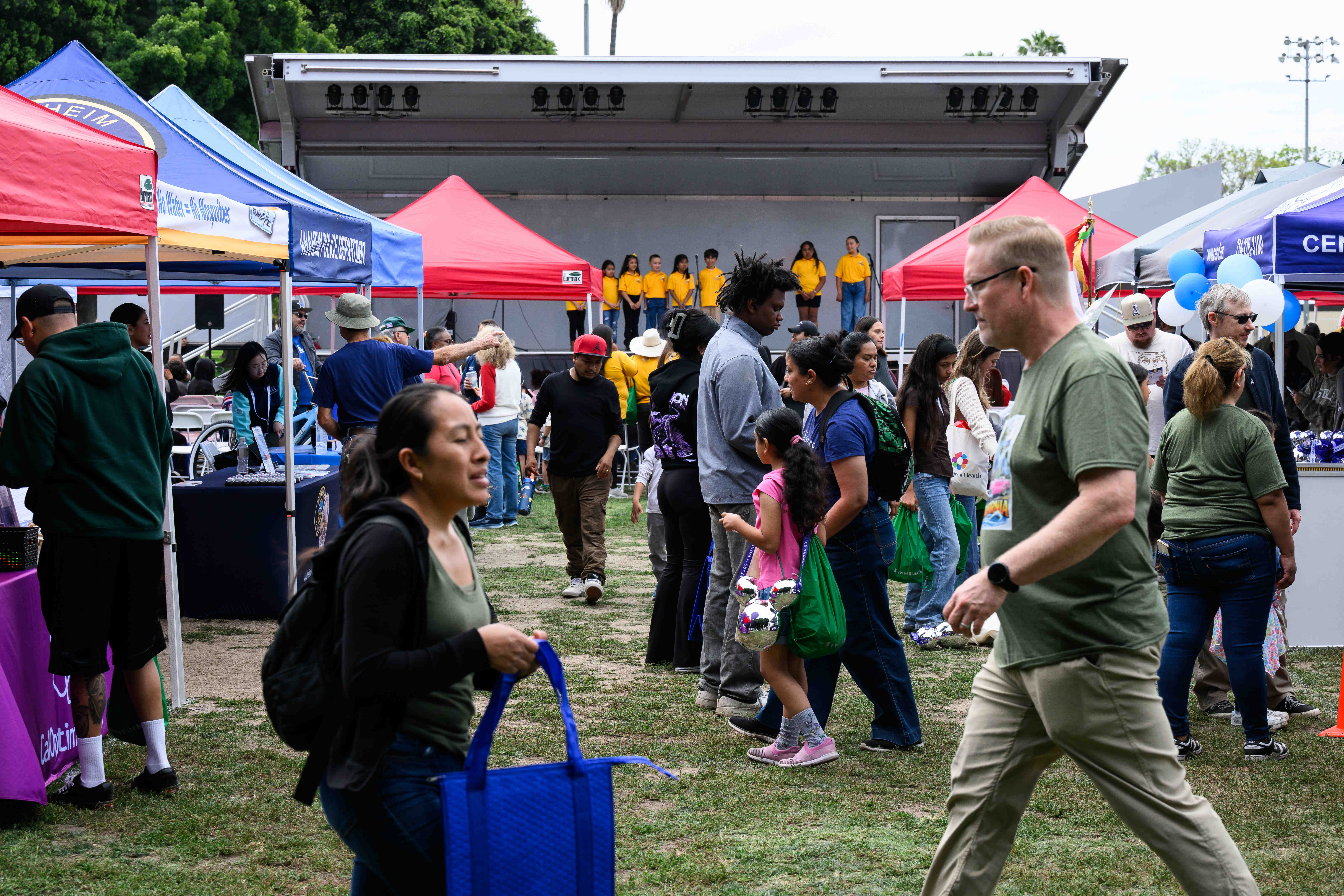People walk along different informational booths during the Show Off...