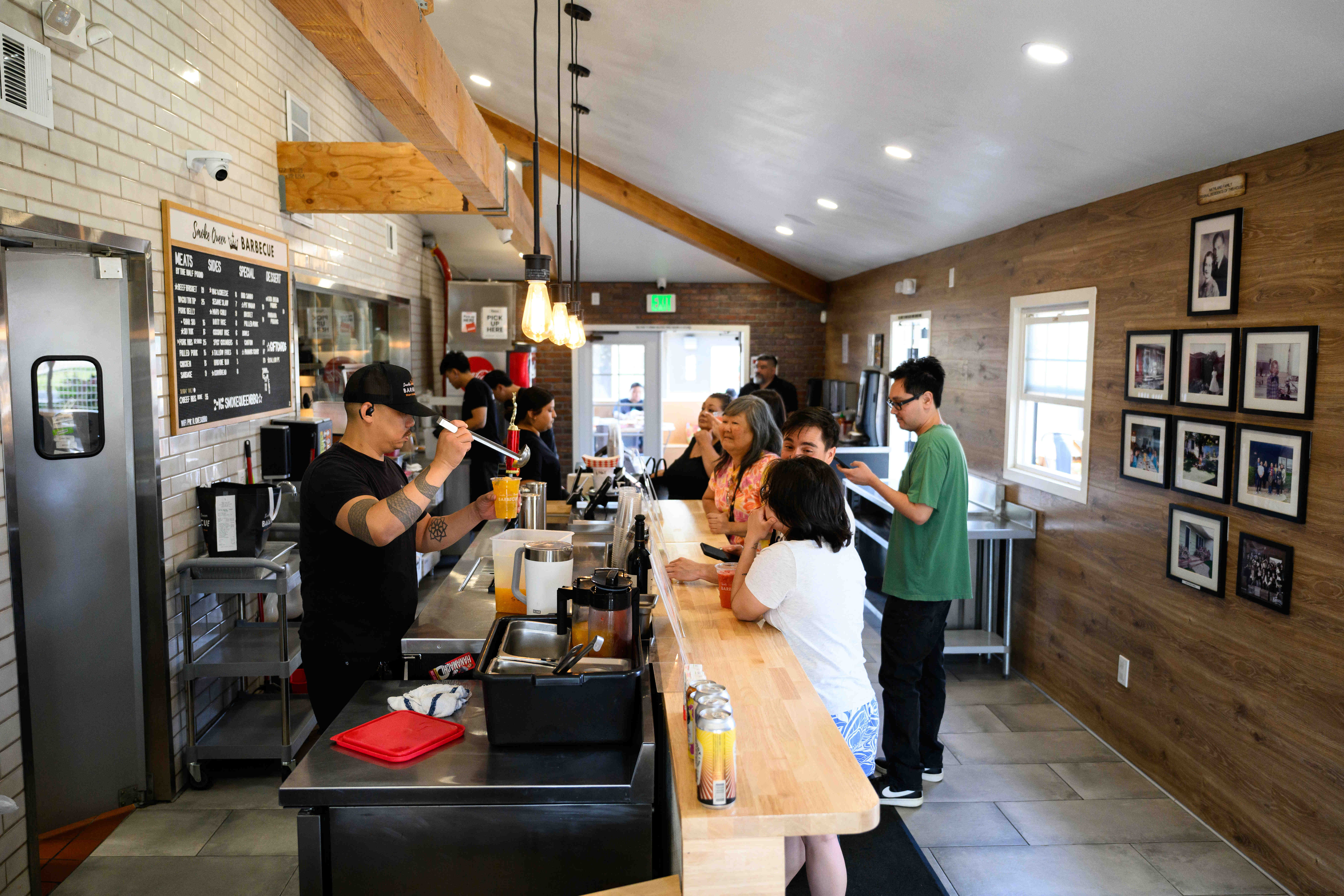 Customers wait in line inside at Smoke Queen Barbecue, Thursday,...