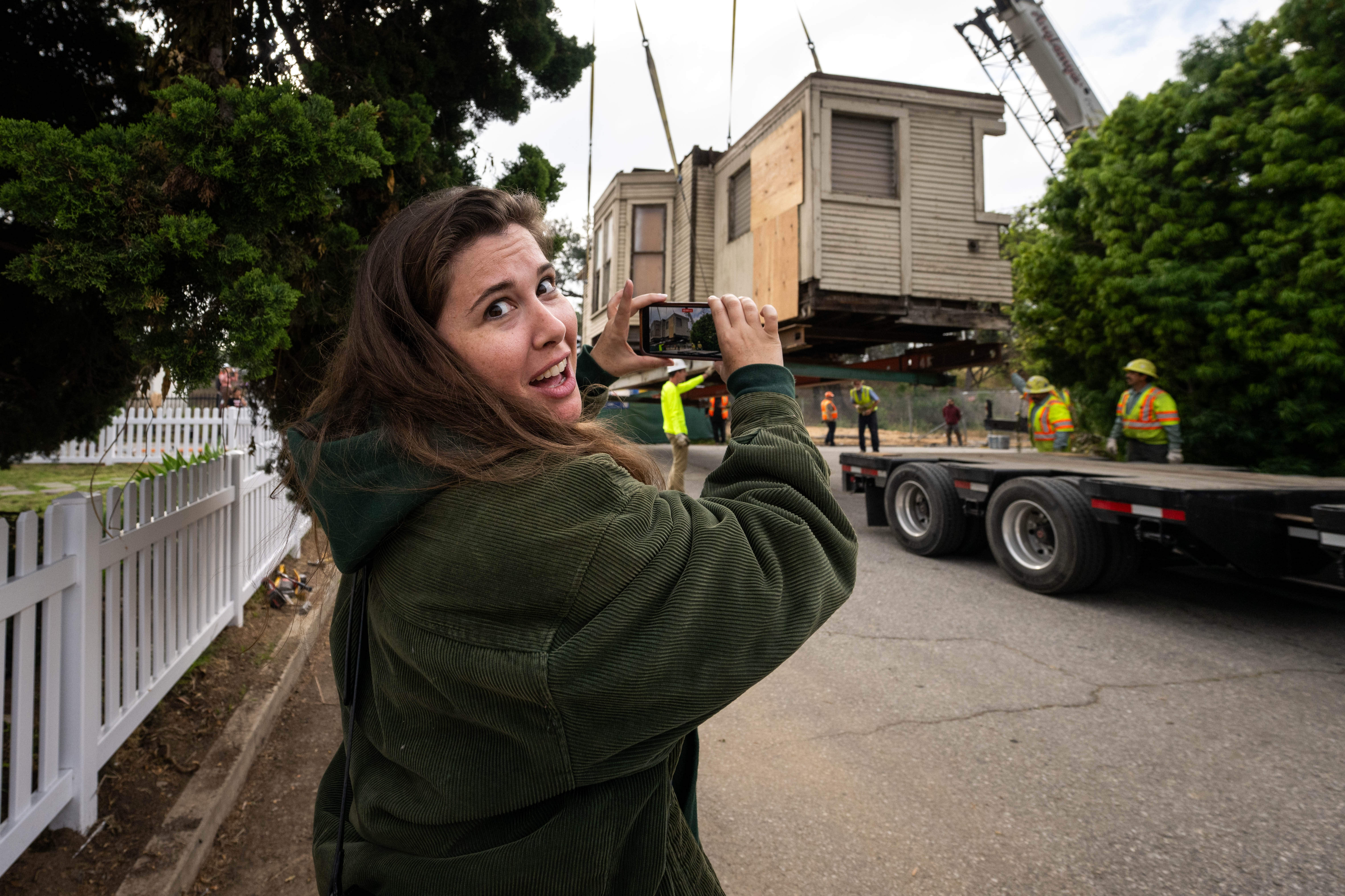 Brooke Lohman-Janz watches an 1895 Victorian-era home being craned onto...