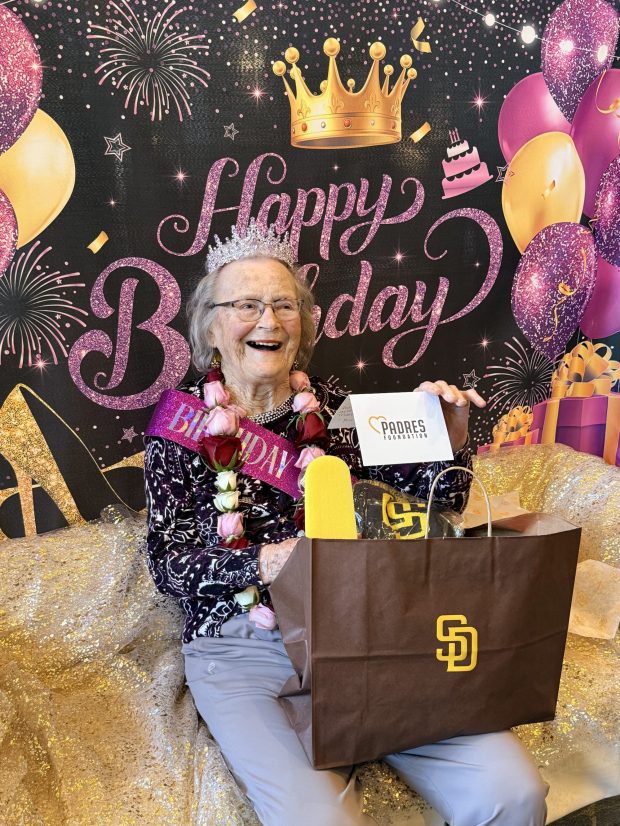 Betty Haver, a San Diego Padres fan for a half-century, was all smiles while seeing the gifts the team gave her to celebrate her 108th birthday. (Sally McNew)
