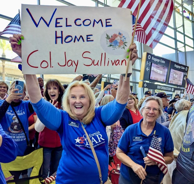 Rincon del Diablo Chapter of DAR members Renee Neale, holding sign, and Joy Schumacher were among those welcoming home Honor Flight veterans on April 27, 2025. (Jennifer Halter)