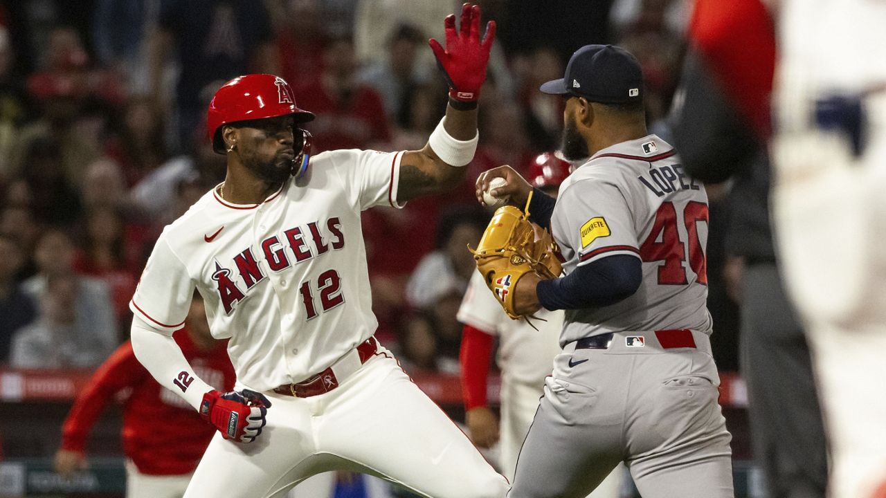 Los Angeles Angels' Jorge Soler (12) and Atlanta Braves' Reynaldo López (40) fight during the fifth inning of a baseball game, Tuesday, April 7, 2026, in Anaheim, Calif. (AP Photo/Ethan Swope)