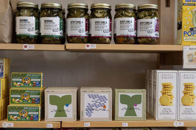Real Mojo Foods’ Hot-n-Zesty pickles are on sale alongside other locally produced items, marked with red tomato stickers, at Superette in Sacramento on Monday, Dec. 1, 2025.