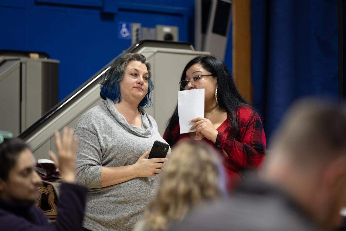 Sacramento City Unified School District board members Tara Jeane, left, and April Ybarra confer during a community meeting about the project to replace the existing grass field at Crocker/Riverside Elementary School on Tuesday.