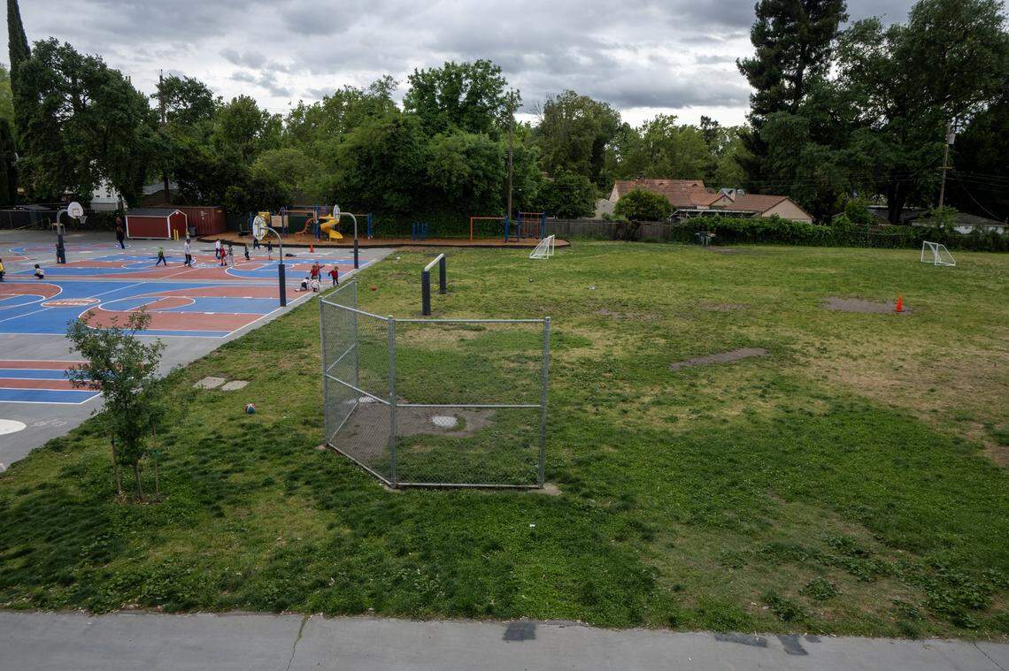 Children play near the field at Crocker/Riverside Elementary School in Sacramento on Tuesday before a meeting at the school about replacing the grass with artificial turf. 