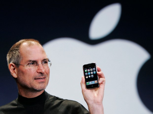 Apple CEO Steve Jobs holds up an Apple iPhone at the MacWorld Conference in San Francisco, in this Jan. 9, 2007, file photo. (AP Photo/Paul Sakuma, File)